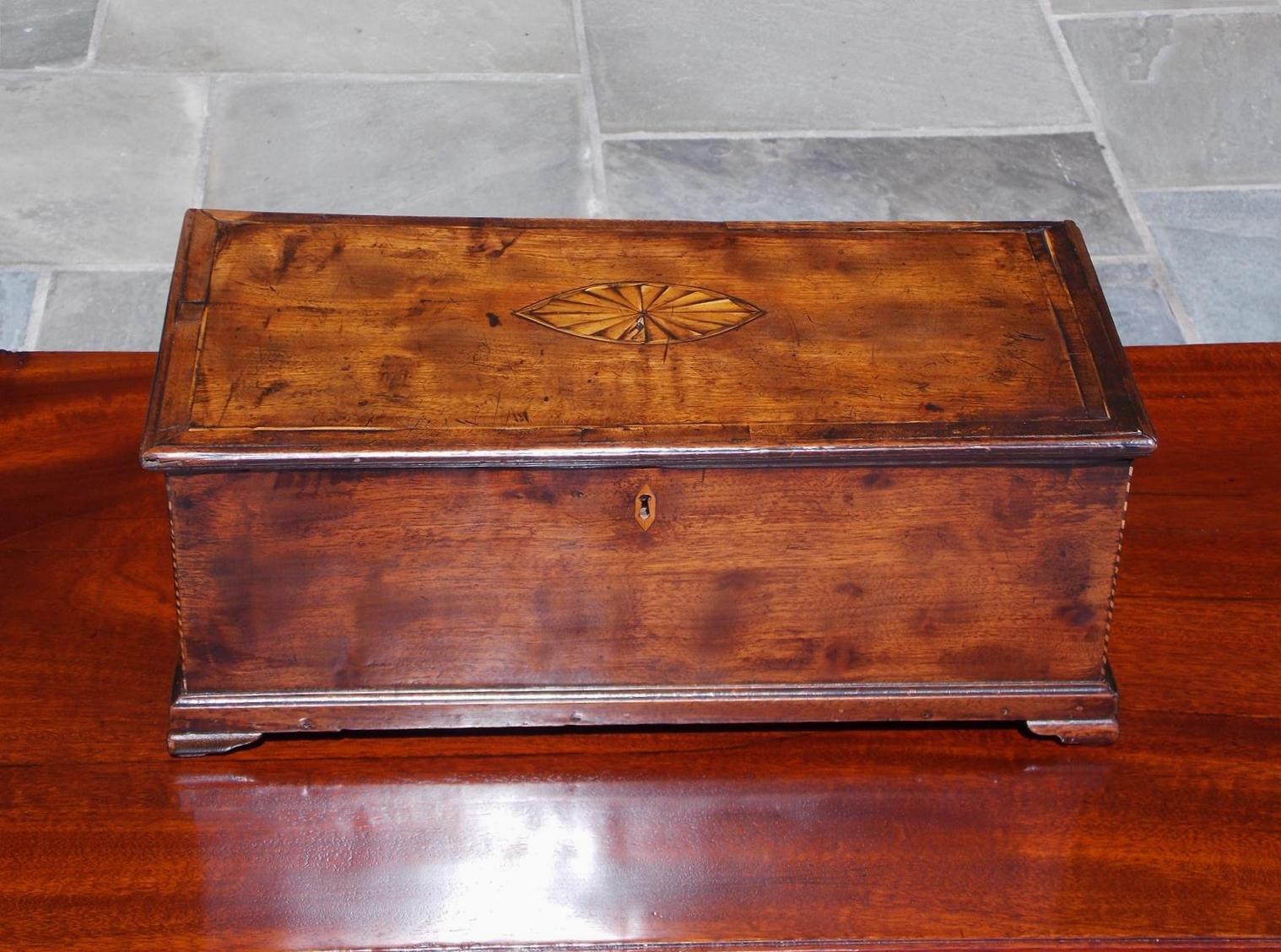 American Chippendale walnut oval satinwood inlaid valuables box with a carved molded hinged lid revealing an interior till with a secret hidden drawer, exterior checkered and sting inlays, centered diamond escutcheon, and resting on the original