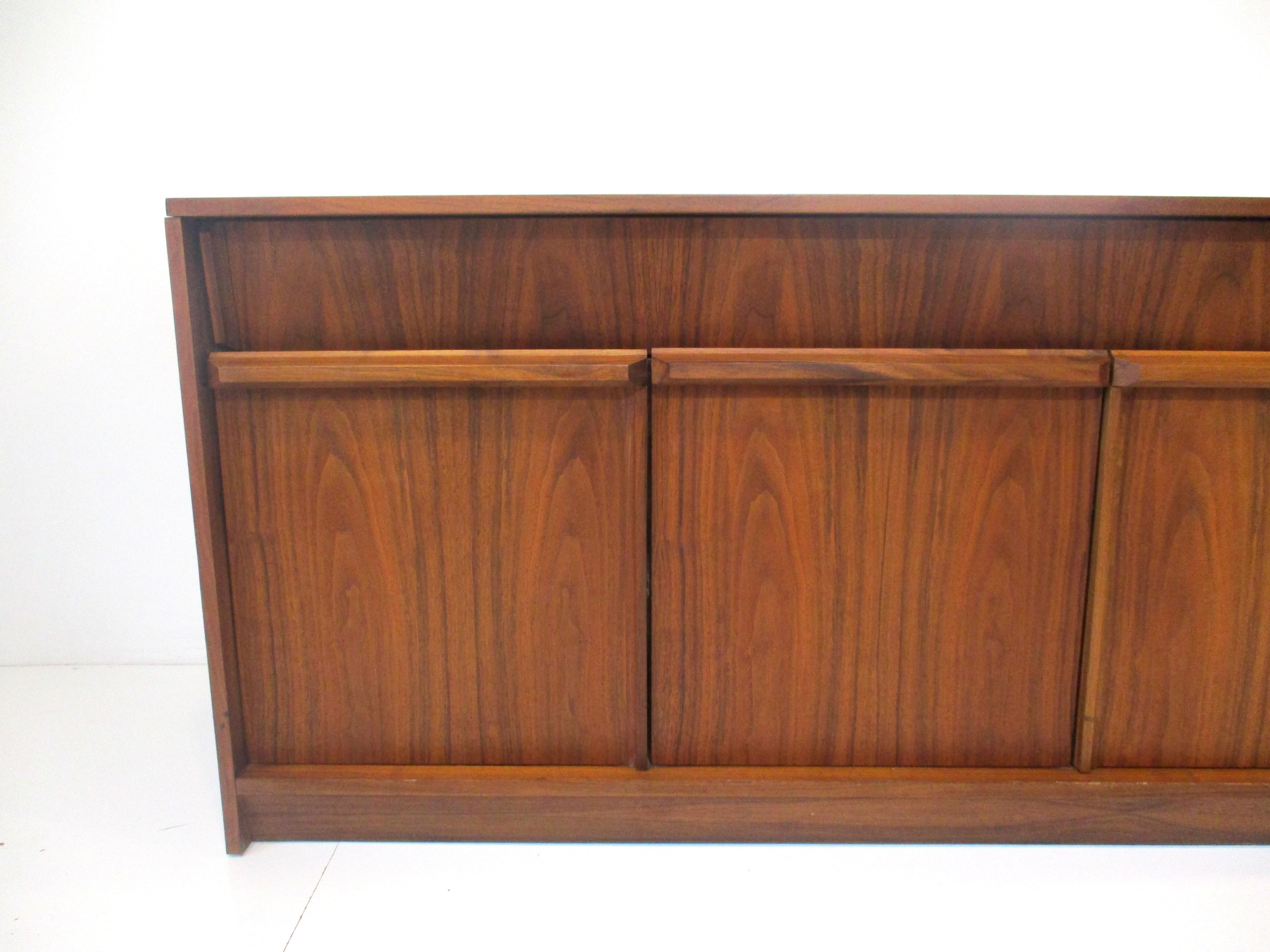 A very well crafted American black walnut stereo cabinet with lifting top and a pull out record storage bin to each side . Inside there are openings for your amp and tuner , included in the cabinet is a Dual 1219 turntable . This cabinets book