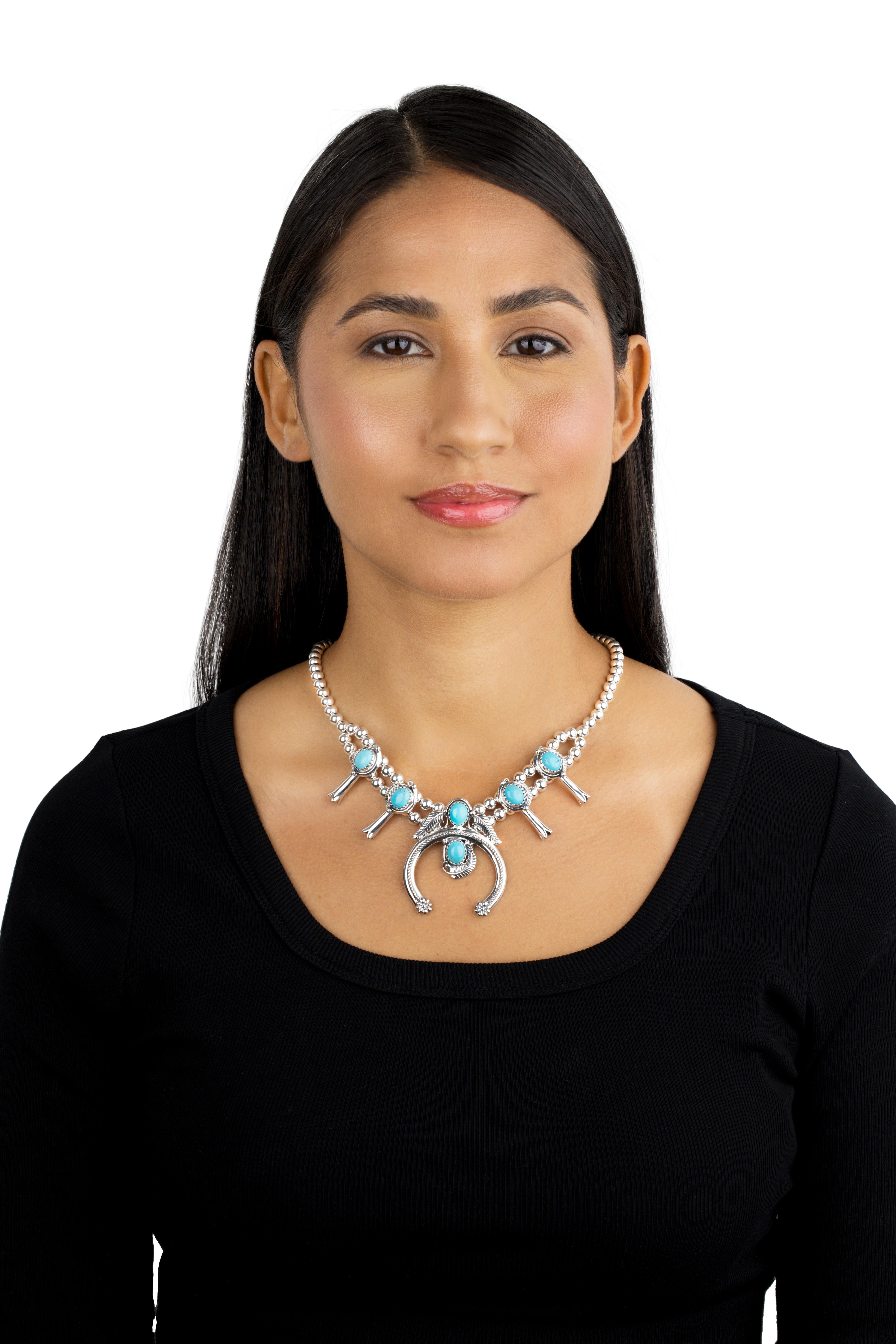 - Collana in argento Sterling di ispirazione sud-occidentale con gemme ovali di turchese Kingman; disegno naja al centro; stazioni di fiori di zucca tra perline rotonde d'argento da 6 mm 
- Lunghezza di 17