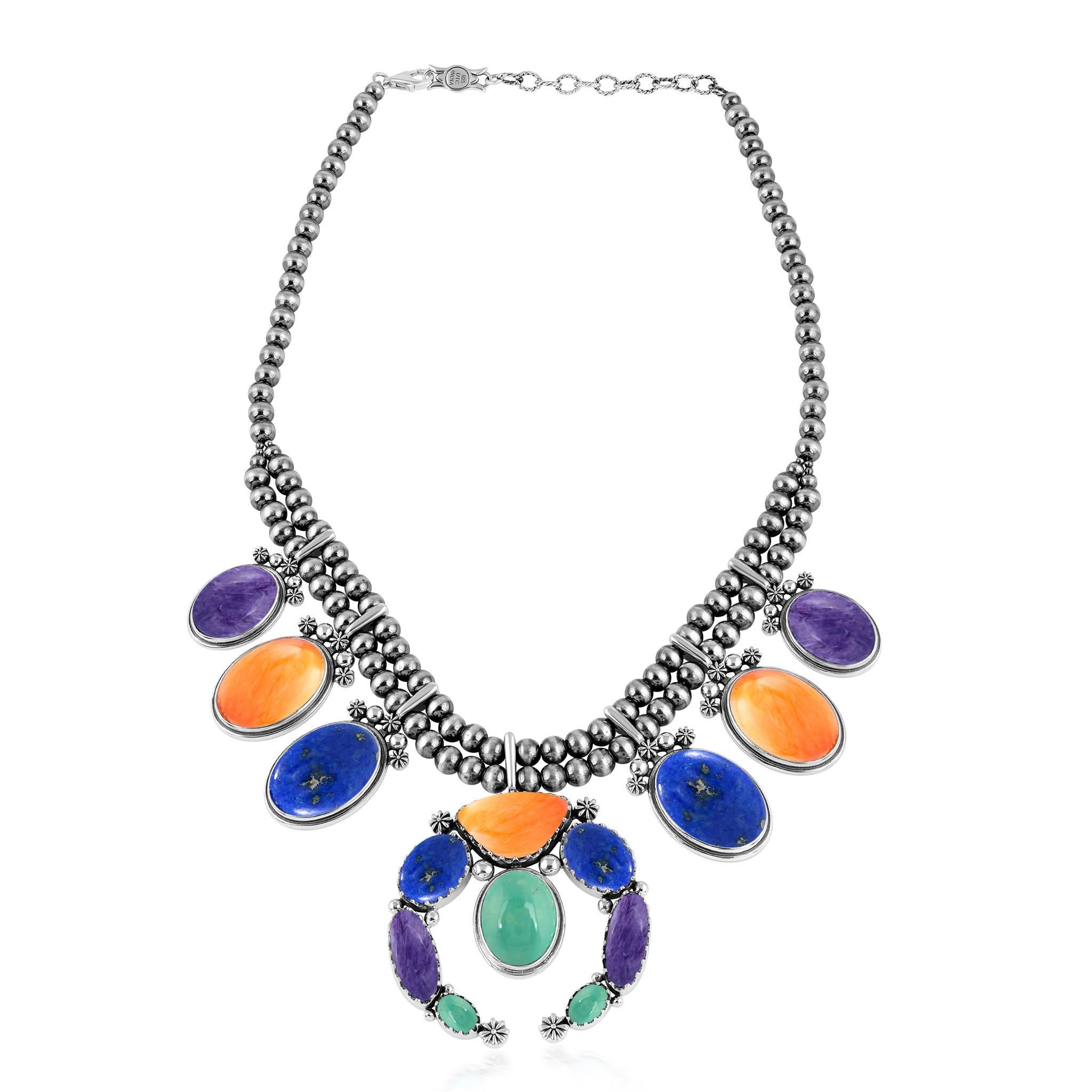 - La collana è caratterizzata da 6 stazioni ovali con cabochon, tra cui Charoite, Ostrica spinosa arancione e Lapis; doppia fila di perle native in argento Sterling; naja centrale con cabochon di Charoite, Lapis, Ostrica spinosa arancione e Turchese
