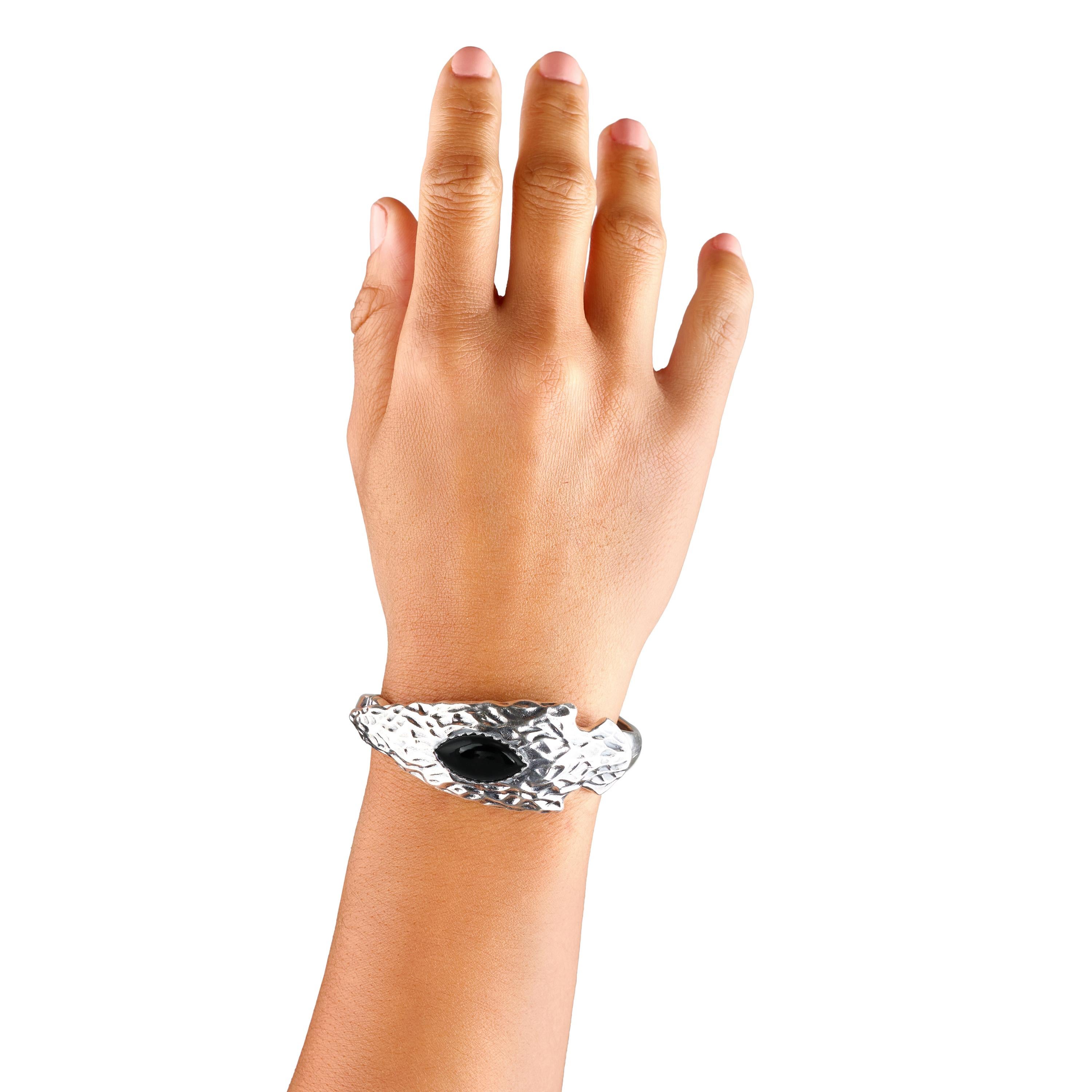 - Bracciale aperto disegnato da Fritz Casuse con cabochon di Onice Nero di 10x20 mm con taglio a marquise; castone dentellato su una punta di freccia in Argento 925 martellata e testurizzata.
- Small si adatta a polsi di 6,25