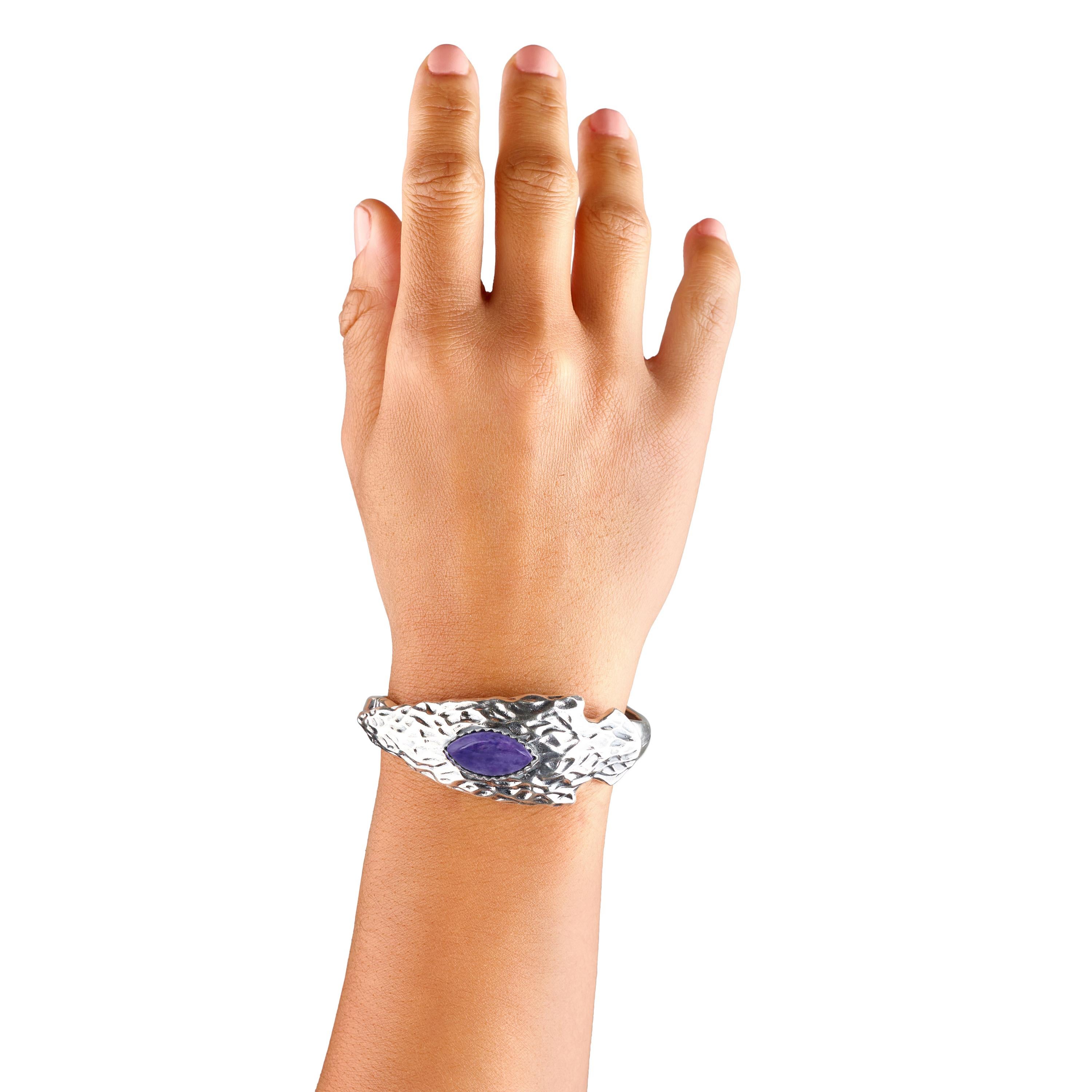 • Bracelet manchette ouvert conçu par Fritz Casuse avec cabochon de Charoite de 10x20mm taillé en marquise, serti sur une pointe de flèche en argent sterling martelé et texturé.
• Le petit modèle convient aux poignets de 6,25