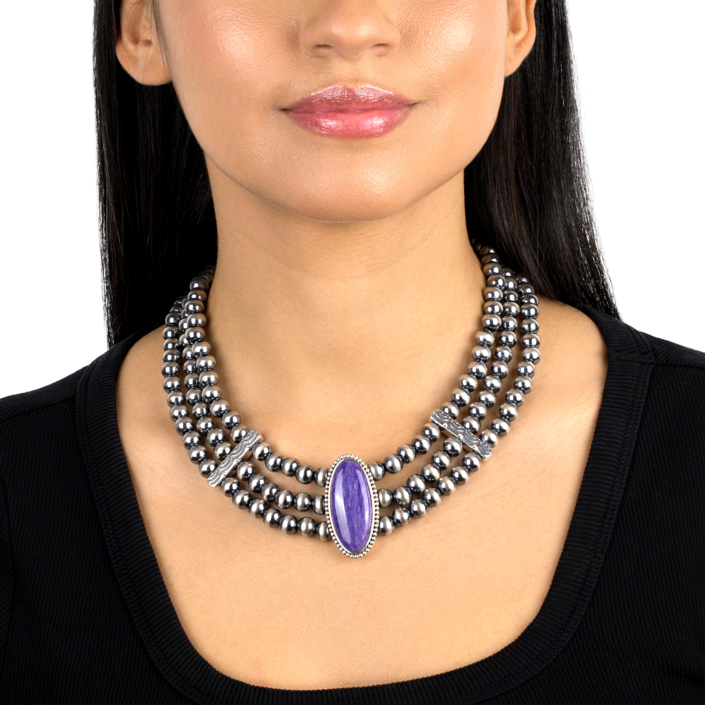 - • Eingeborenes Perlencollier mit einem dreifachen Strang aus 8mm .925 echtem Sterling Silber mit einem 16mm x 36mm großen Charoite-Cabochon in einer Perlenlünette in der Mitte
- • 17