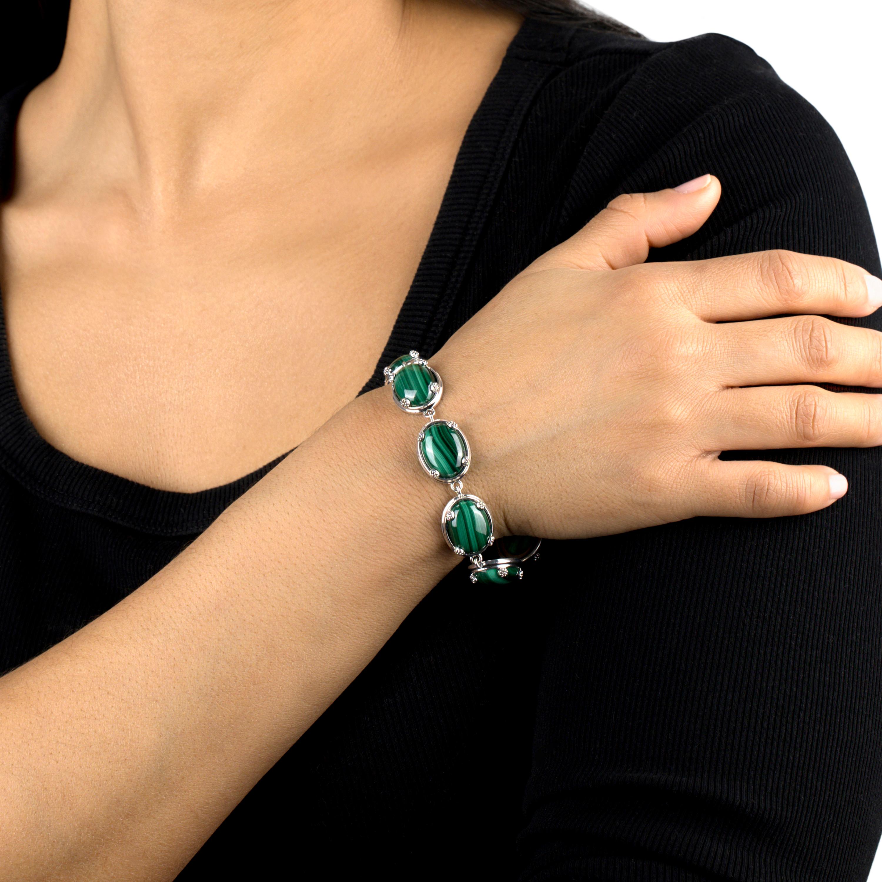 • Le bracelet présente des cabochons ovales de malachite de 16 mm x 12 mm sertis dans des griffes et des accents de fleurs de concha et fixés à l'aide d'un fermoir à genouillère en corde.
• Le bracelet mesure environ 0,59