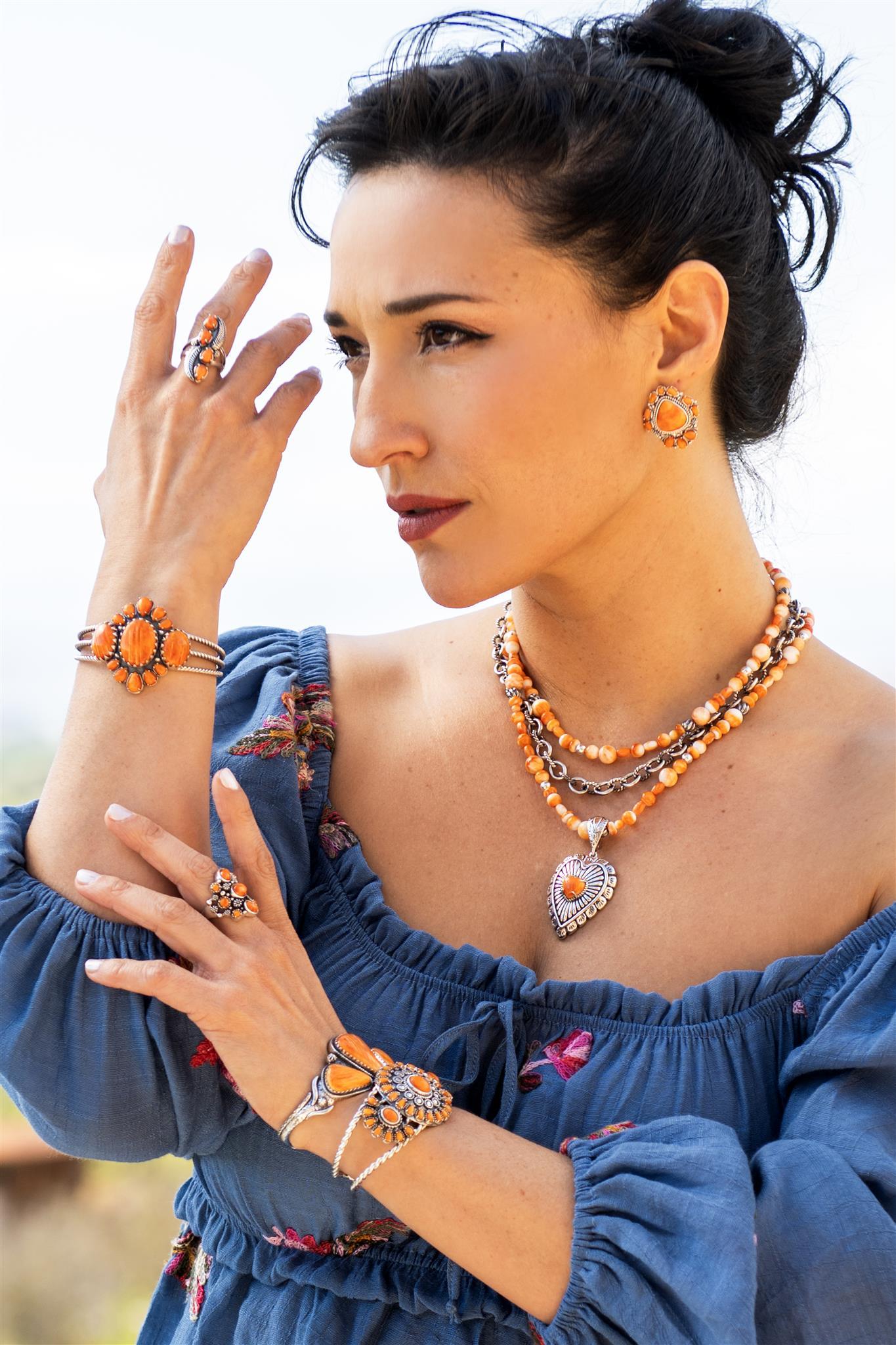 - • Manschette mit 3 ovalen Orange Spiny Oyster Cabochons in gezackten Lünetten; 10 in Zacken gefasste Orange Spiny Oyster Edelsteine im Birnenschliff in 3 Größen
- • Strukturierte 3-reihige offene Sterling Silber Manschette; 1,75