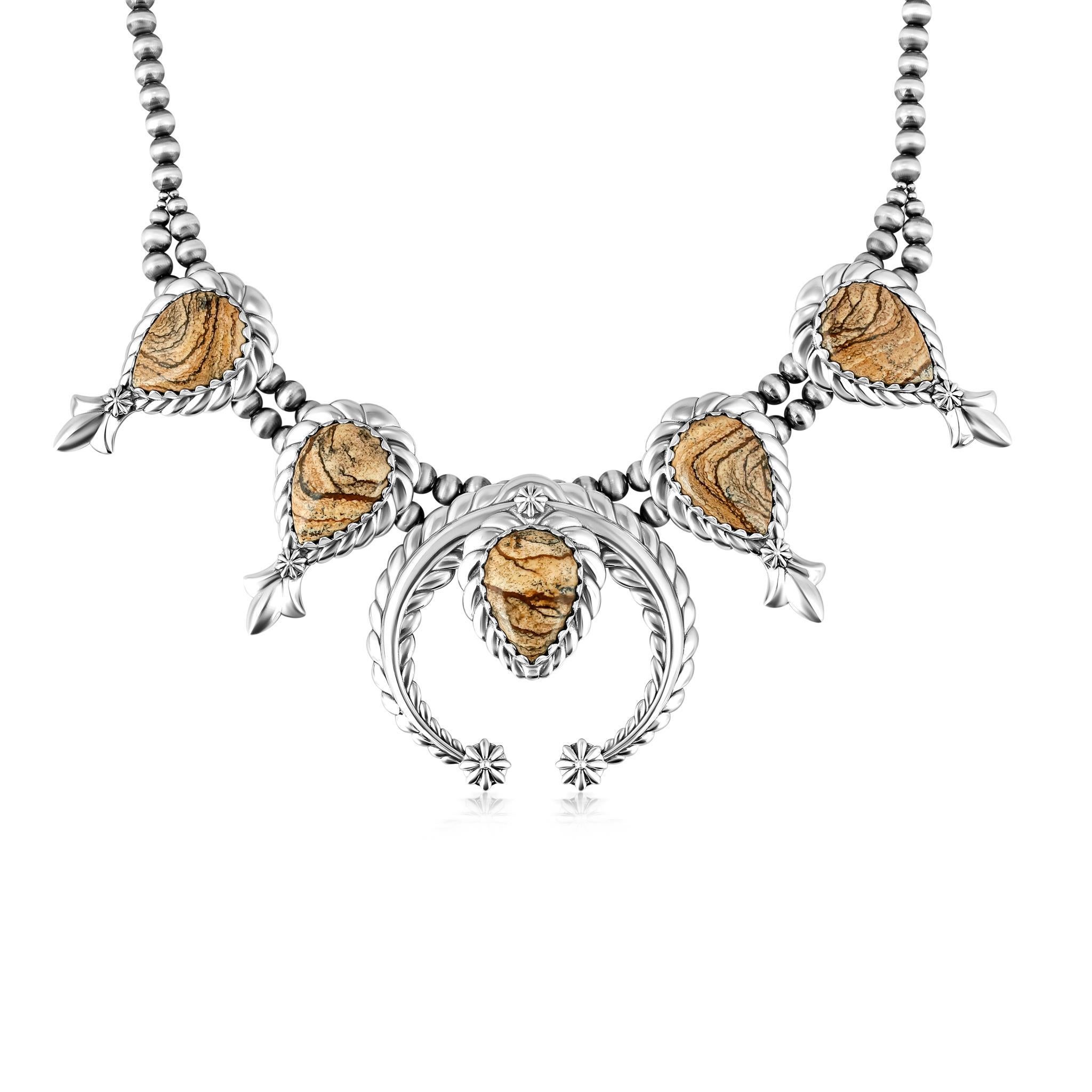 • Collier en argent sterling avec 5 cabochons de jaspe photo taillés en poire et un naja central ; serti en bélière dentelée ; détails de corde et de fleur de courge.
• Chaîne de 17