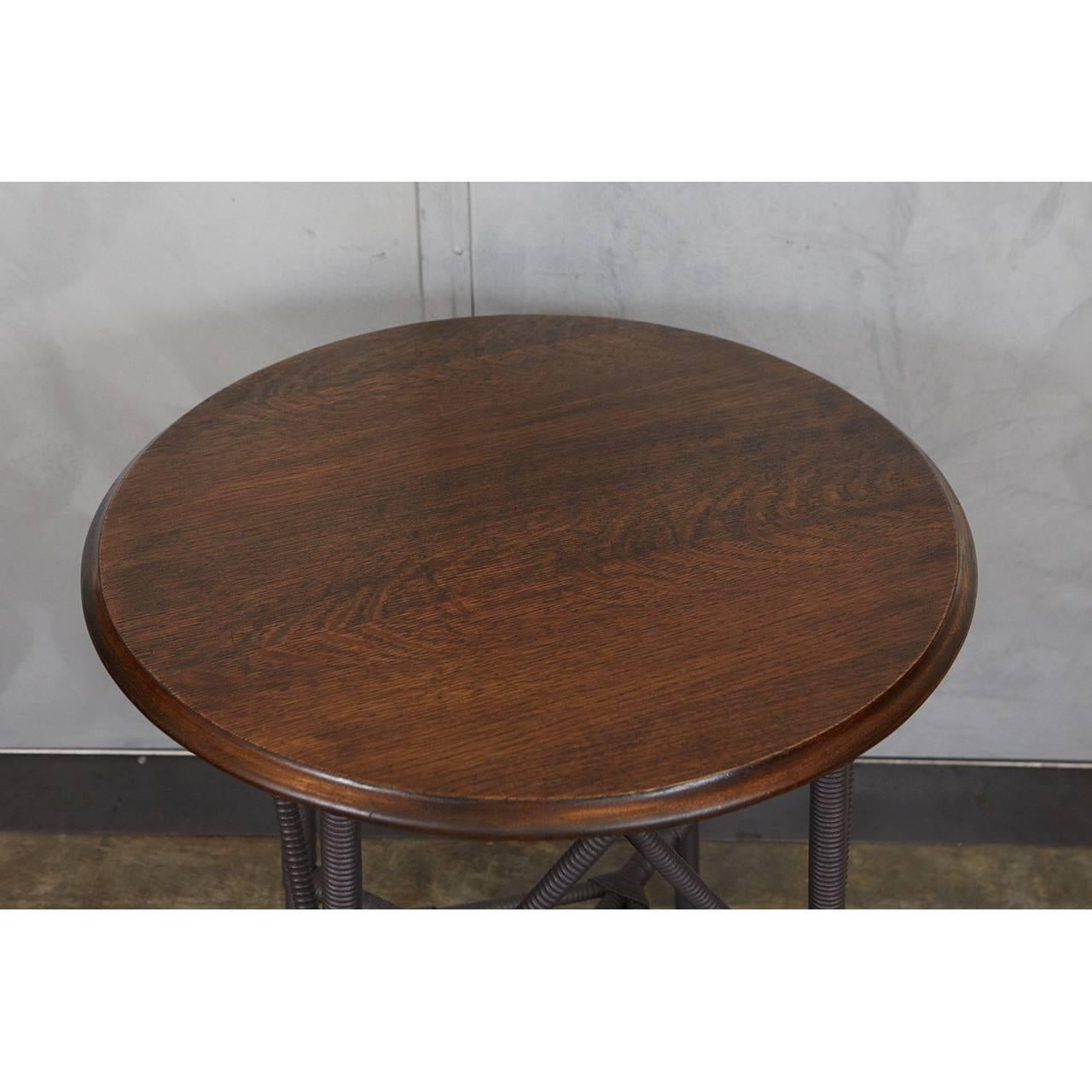 This wood and wicker table with a round oak top is a very special piece. The legs
are intricately turned to mimic the wicker pattern with wicker wrapping on the bottom portion. Note the nice design of the angled side supports and lower box