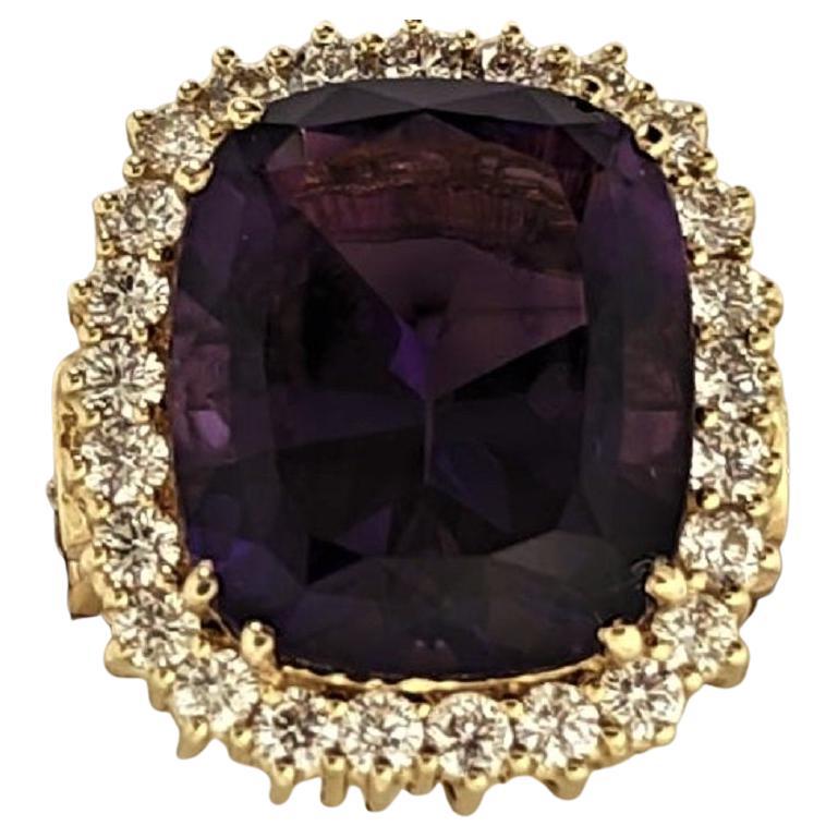 Surrounded by a halo of 25 small diamonds weighing 1.57 cts, this 16.12 ct Zambian Amethyst shines with intense yet soft and calming color.  The shoulders of the slightly tapered ring shank each contain 3 graduated diamonds (6=1.05 cts) set in a