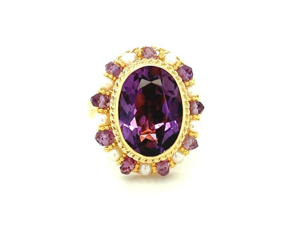 This ring features a beautiful oval faceted 9.90 carat amethyst in an intricate design of handmade 18k yellow gold filigree. The rich purple amethyst is bezel set and encircled by 2mm seed pearls and amethyst beads that are hand-strung on fine, 18k