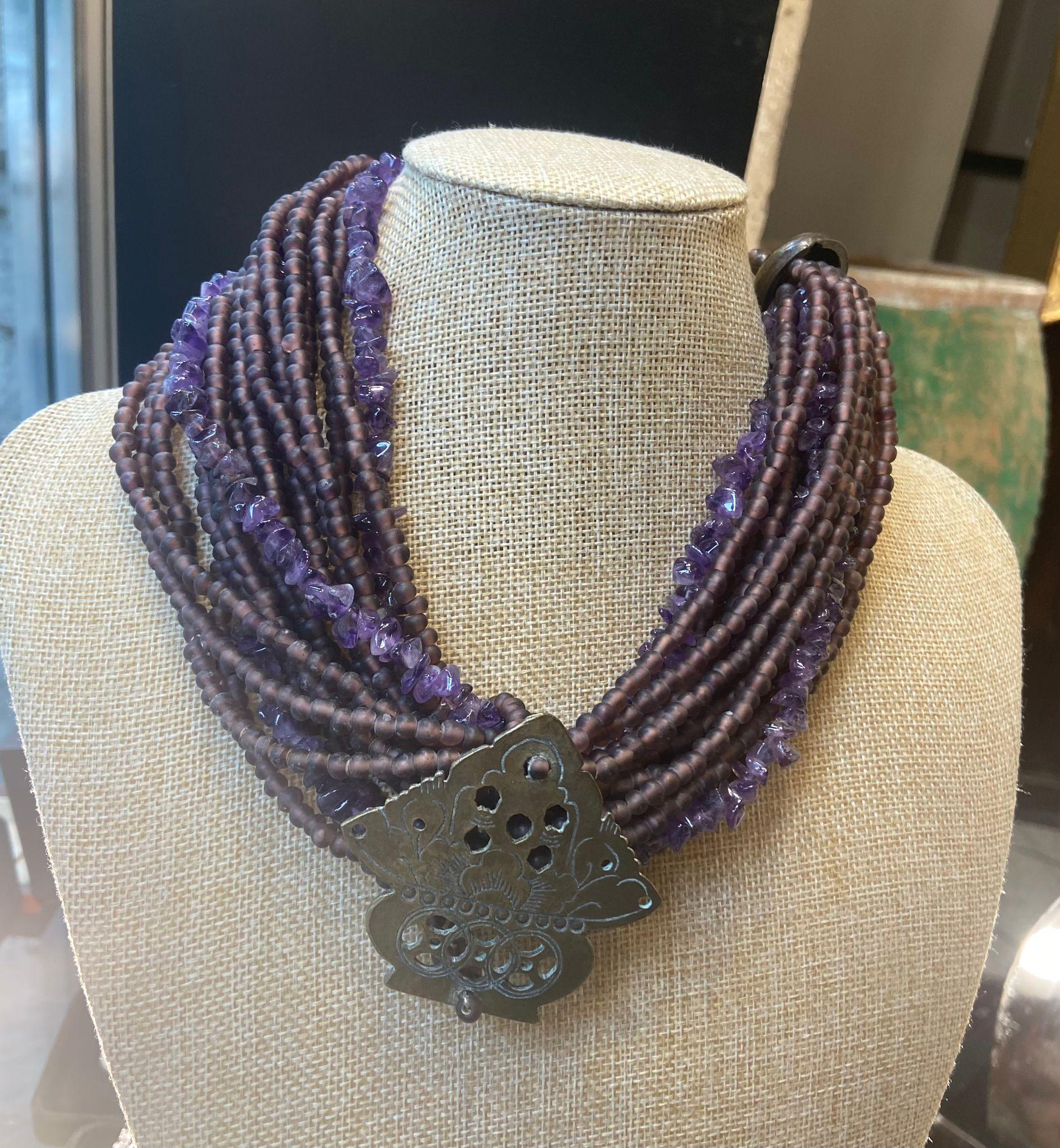 Original jewel in bronze and amethyst beads handmade , artisan piece , 20th century. It is a magnificent jewel composed of a pyramid-shaped central piece, made of chiseled bronze, and which has carved and perforated decorations that create an