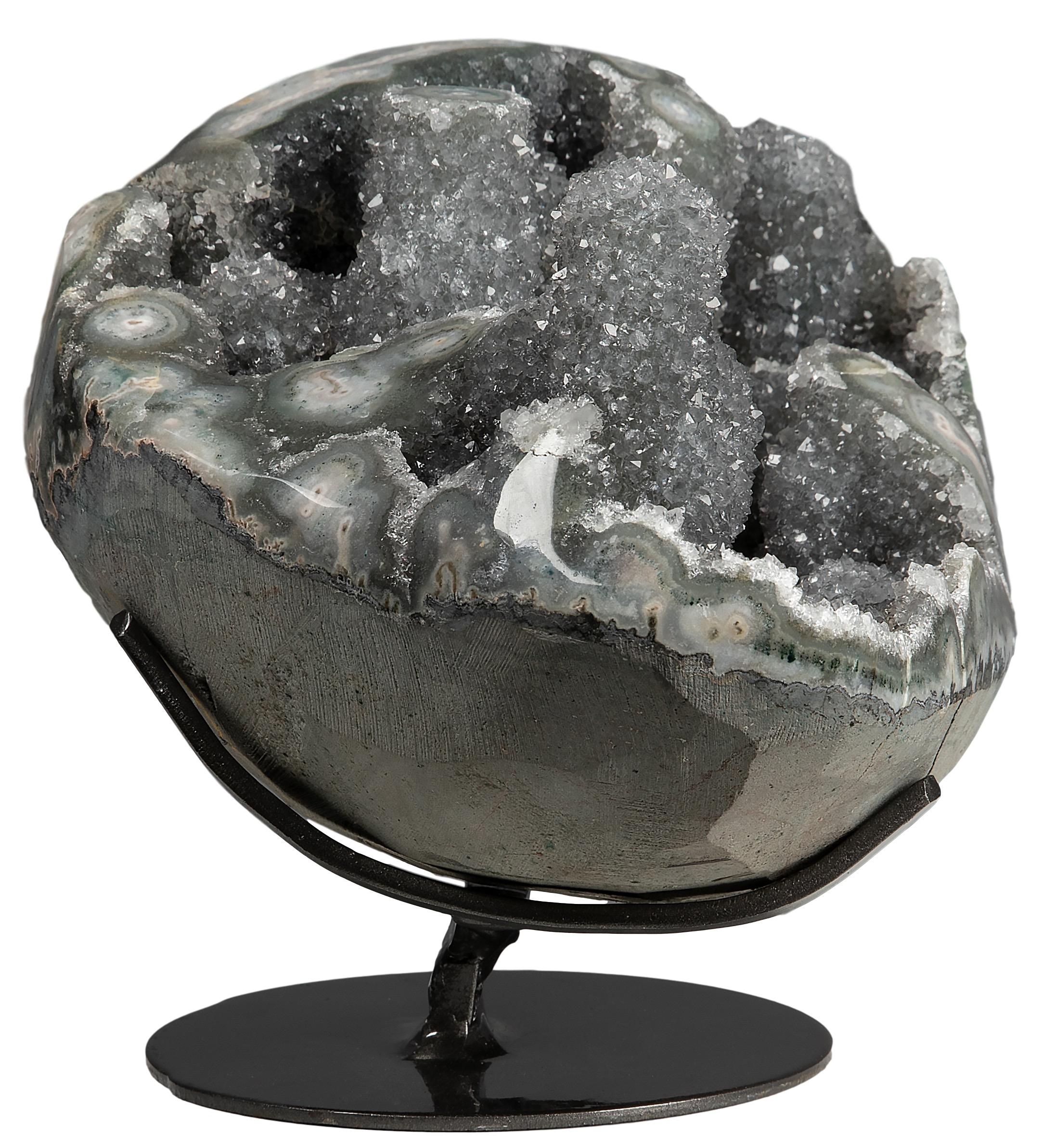 An impressive half geode, this piece is composed of blue grey druze, with beautiful multiple stalactite formations. 

The edges of this beautiful mineralogical piece have been polished, and so it is possible to appreciate a layer of green