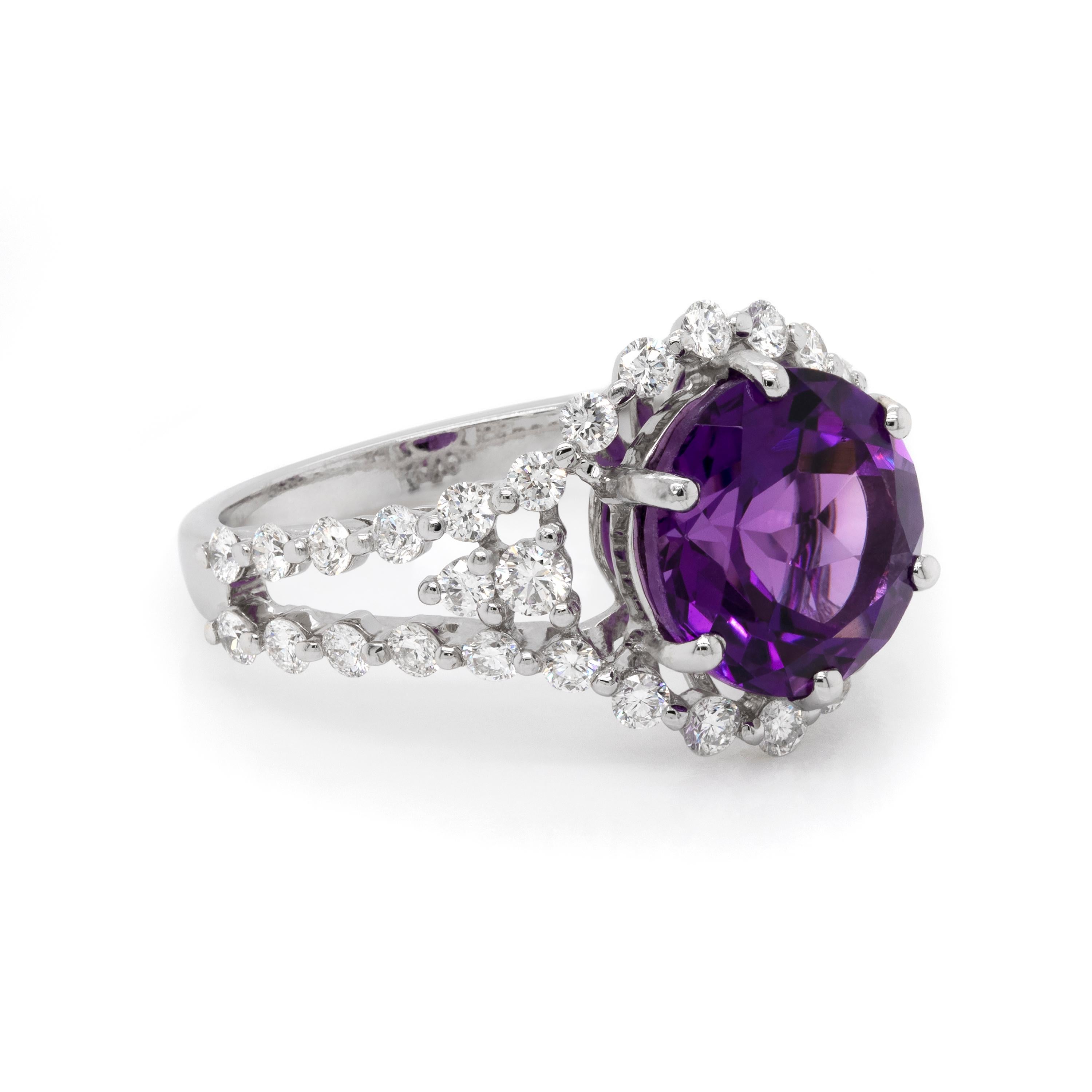 Beautiful dress ring featuring an impressive round shaped amethyst in the centre, weighing a total approximate weight of 3.00ct, mounted in a six claw, open back setting. The amethyst is embellished by a claw set halo of round brilliant cut diamonds
