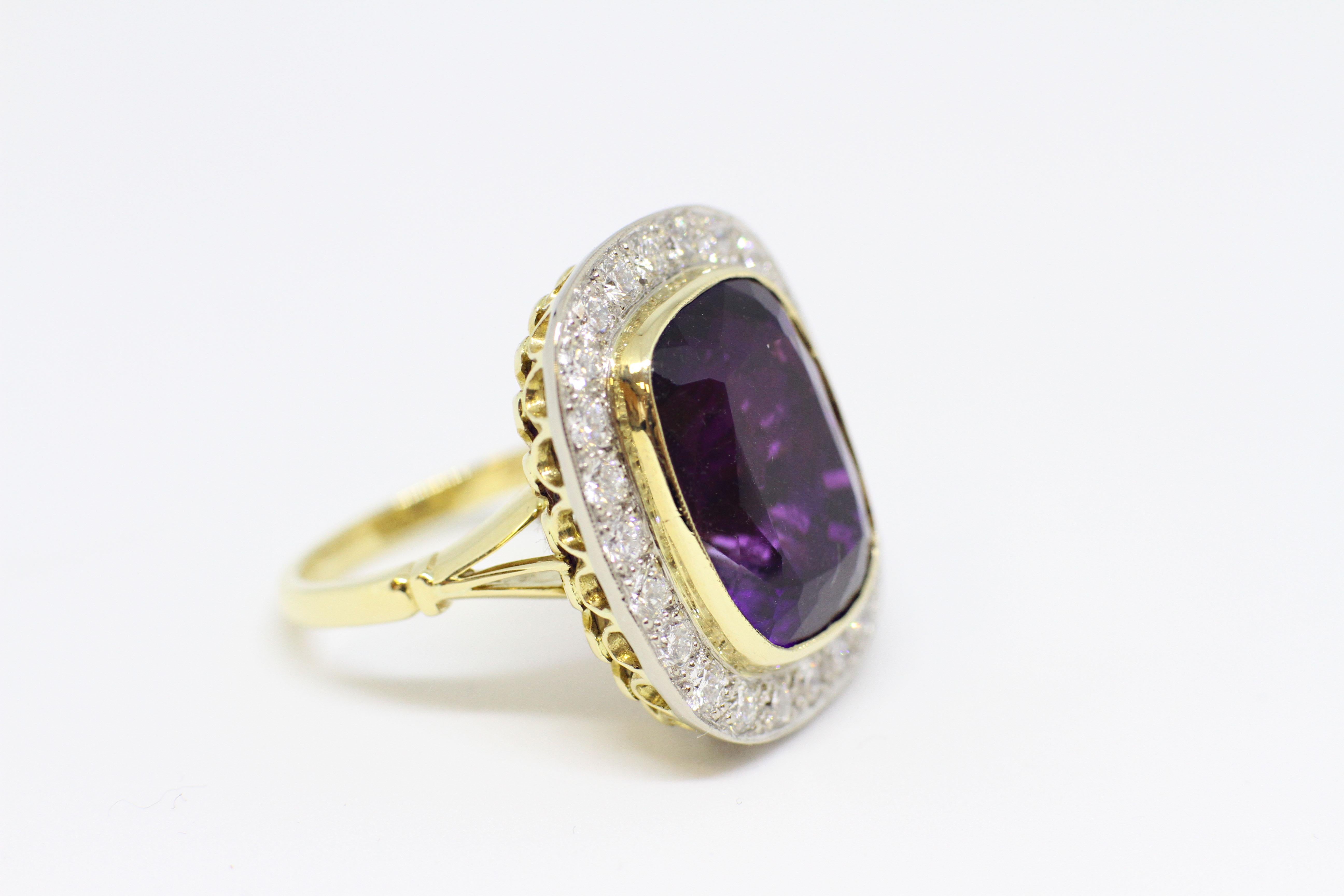 Amethyst and diamond cocktail cluster ring set with a cushion shape amethyst in an open back rub-over setting with an approximate weight of 13.00 carats, surrounded by twenty four round brilliant cut diamonds of fine quality in grain settings with a