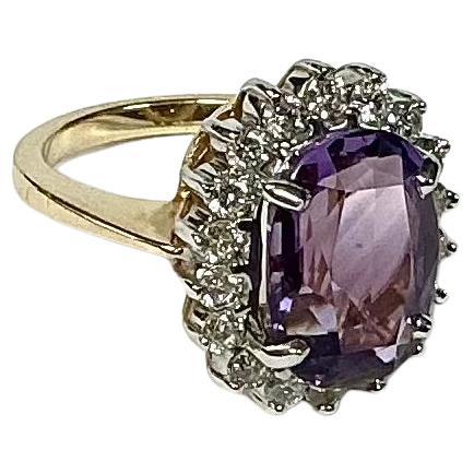14K Gelbgold Amethyst und Diamant Cocktail Ring. Der Ring zeigt einen ovalen Amethysten von etwa 6 Karat, umgeben von 18 kleinen runden Diamanten im Brillantschliff. Ungefähre Größe 6. Ring wiegt 8,91 Gramm und hat 14k Punze Stempel. 