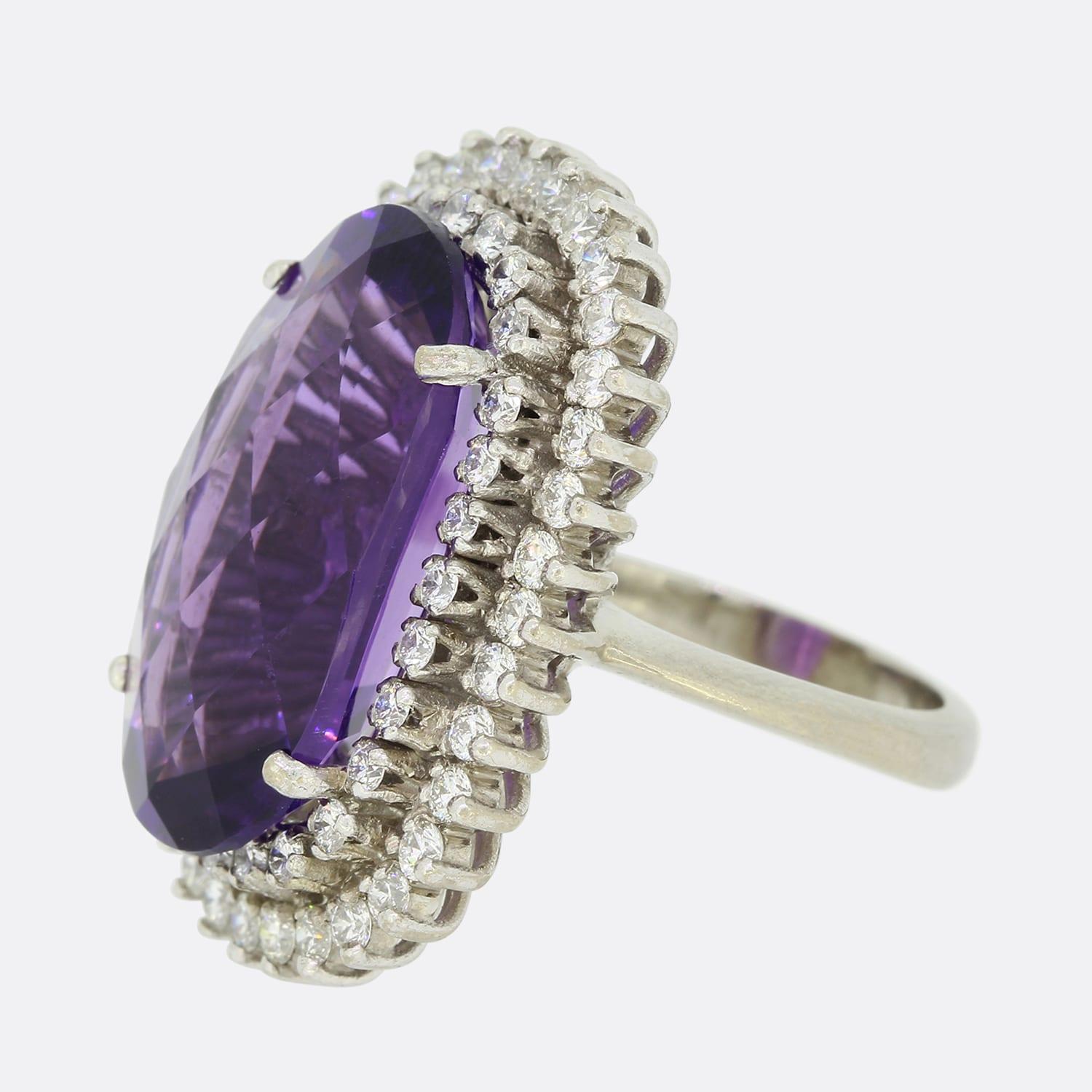 Dies ist ein Cocktailring aus 18 Karat Weißgold mit einem Amethysten und einem Diamanten. Der zentrale Amethyst ist groß und hat eine facettierte Spitze. Er sitzt in der Mitte von 2 Schichten funkelnder runder Diamanten im Brillantschliff.

Zustand: