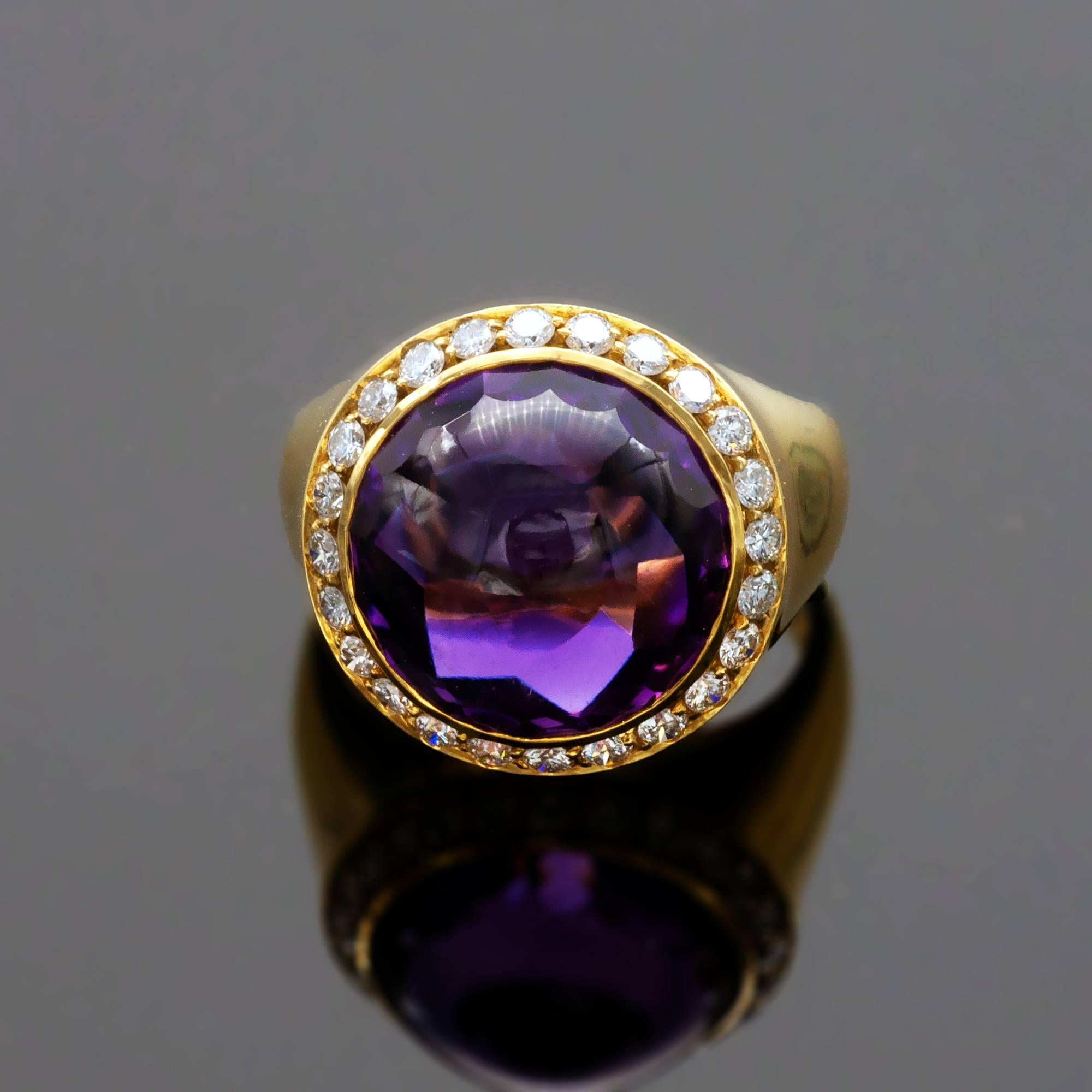 Elegant round amethyst and diamond ring. The center stone has a very unique cut: it is a round cabochon with a row of facets at its base and large facets on its back bring even more life to it. A very intriguing and elegant gem indeed!  Around the