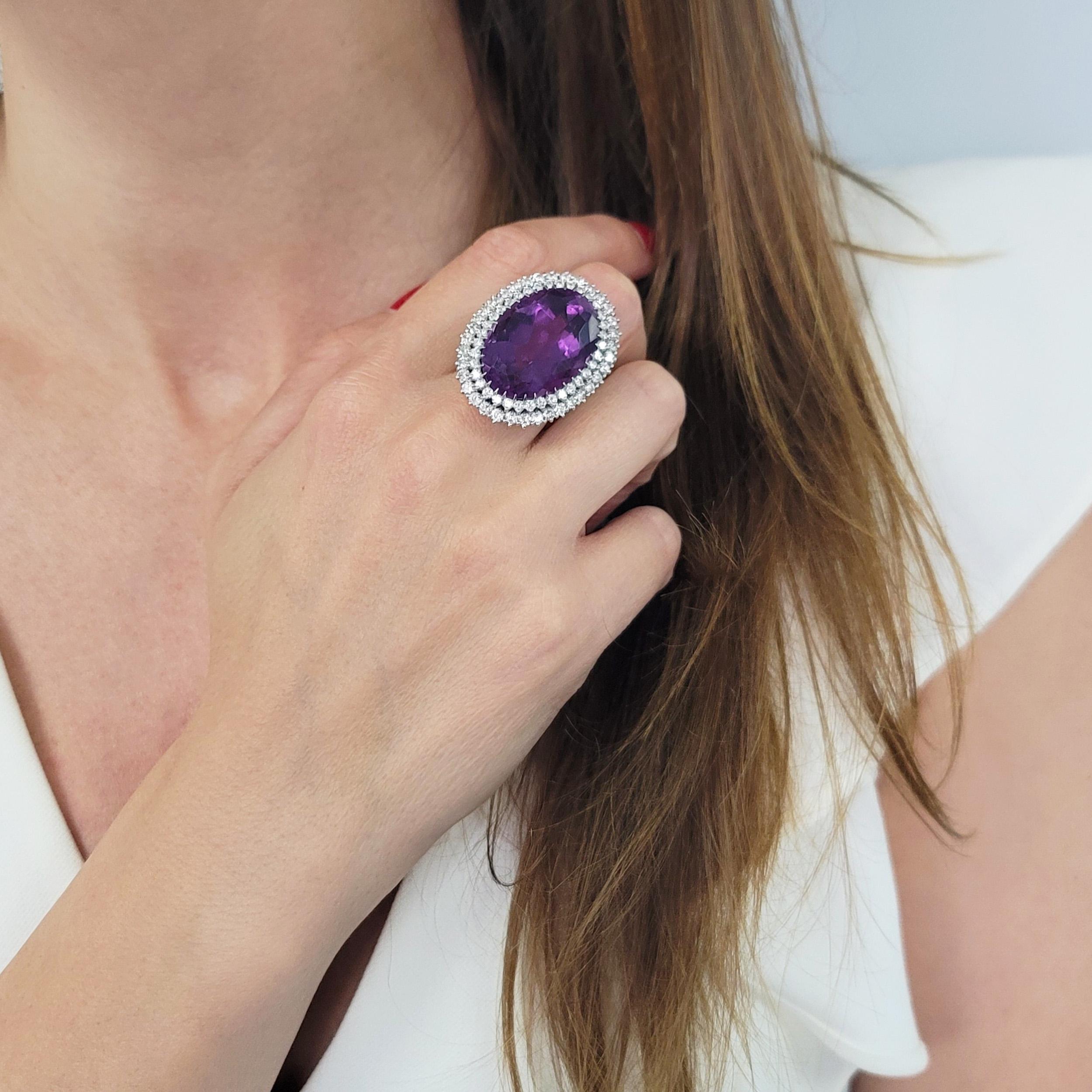 Bague cocktail en améthyste et diamant en or blanc 18k. Le site
La bague est ornée d'une améthyste ovale au centre, entourée d'une améthyste en forme d'anneau.
double halo de diamants. L'améthyste pèse
environ 30.00ct, mesure environ 25mm
x 18 mm,