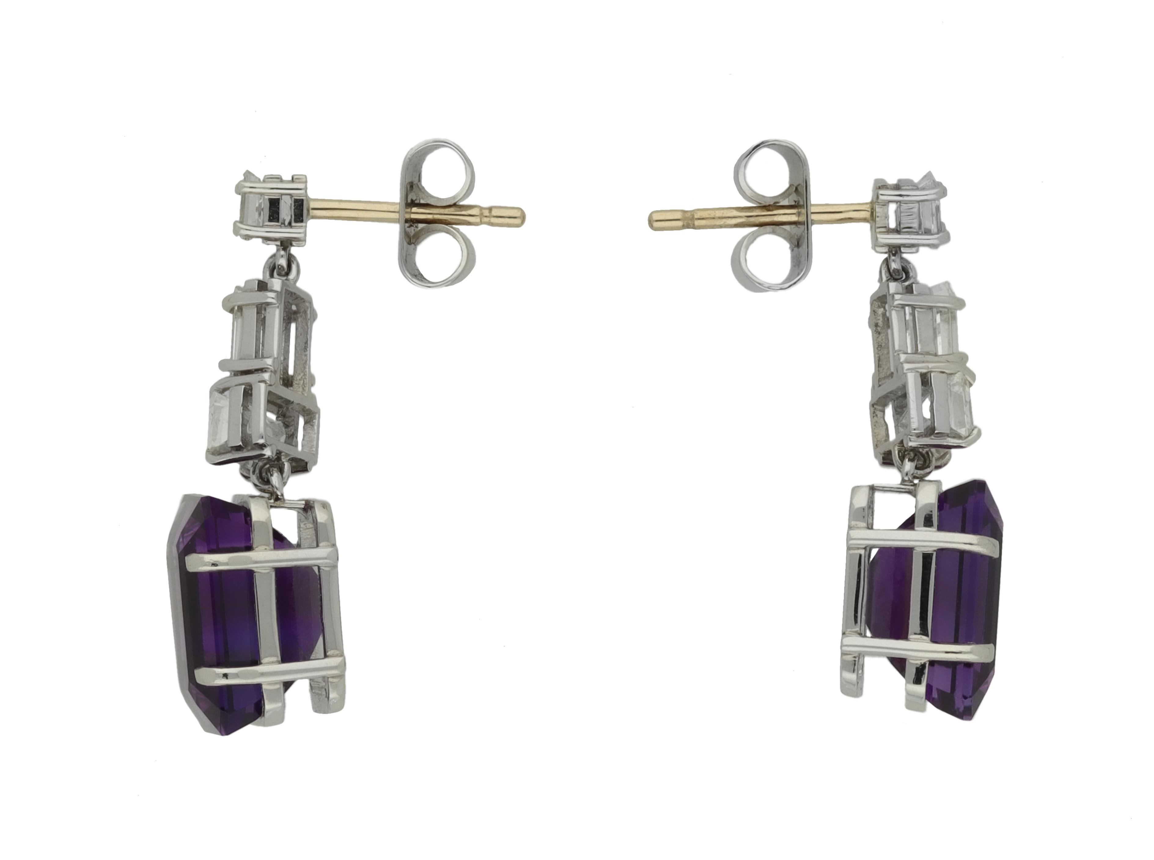 Amethyst and diamond drop earrings. A matching pair, each set with an octagonal emerald-cut natural amethyst, two in total, in an open back claw setting with a combined approximate weight of 6.72 carats, further set with two rectangular baguette cut