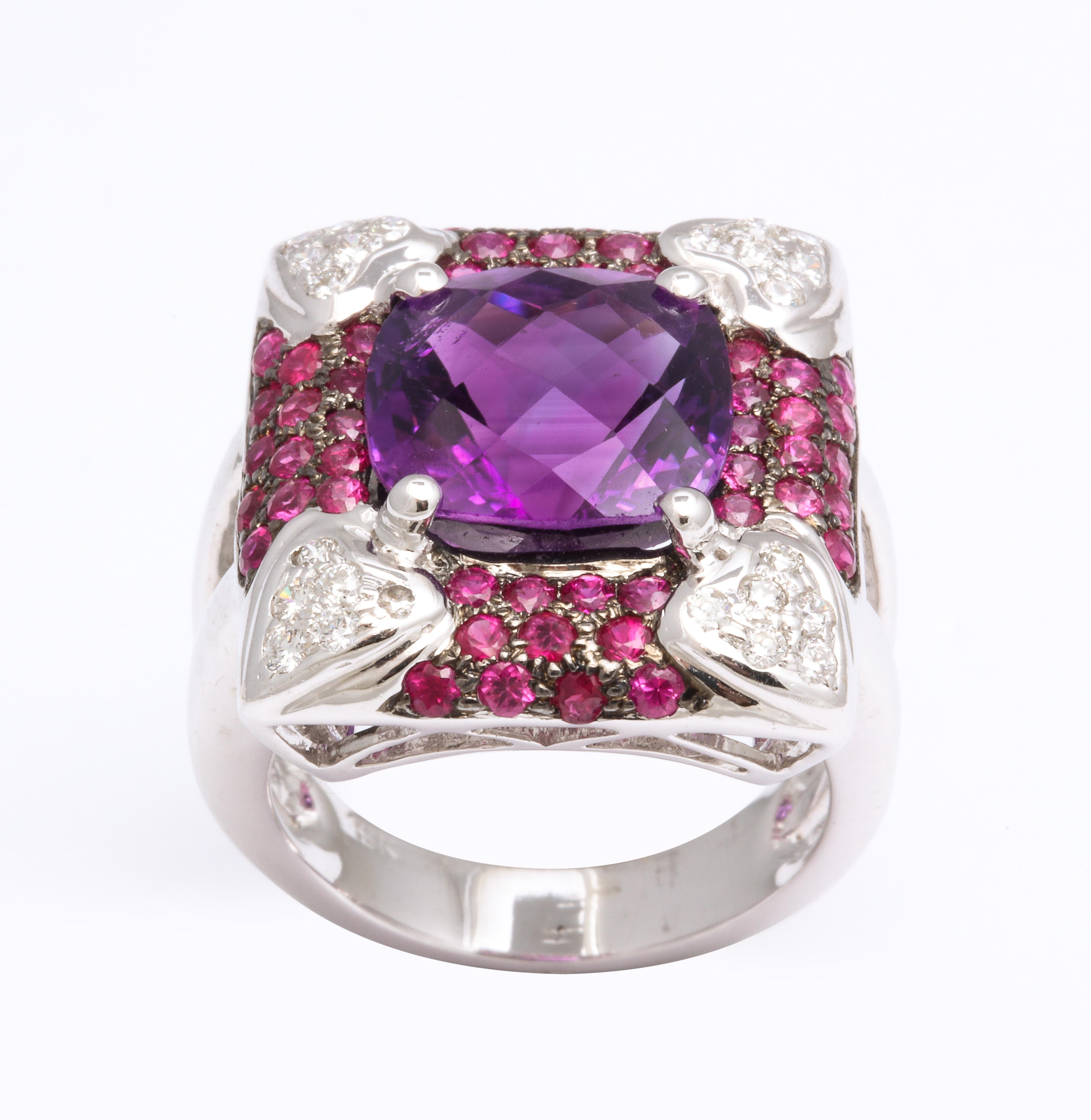 
A one of a kind ring, beautifully designed.

Center 5.51 carat cushion cut Amethyst.

The center stone is set in an 18k white gold ring encrusted in 1.29 carats of Ruby and .35 carats of diamonds in heart shape designs. 

Currently a size 6.5, this