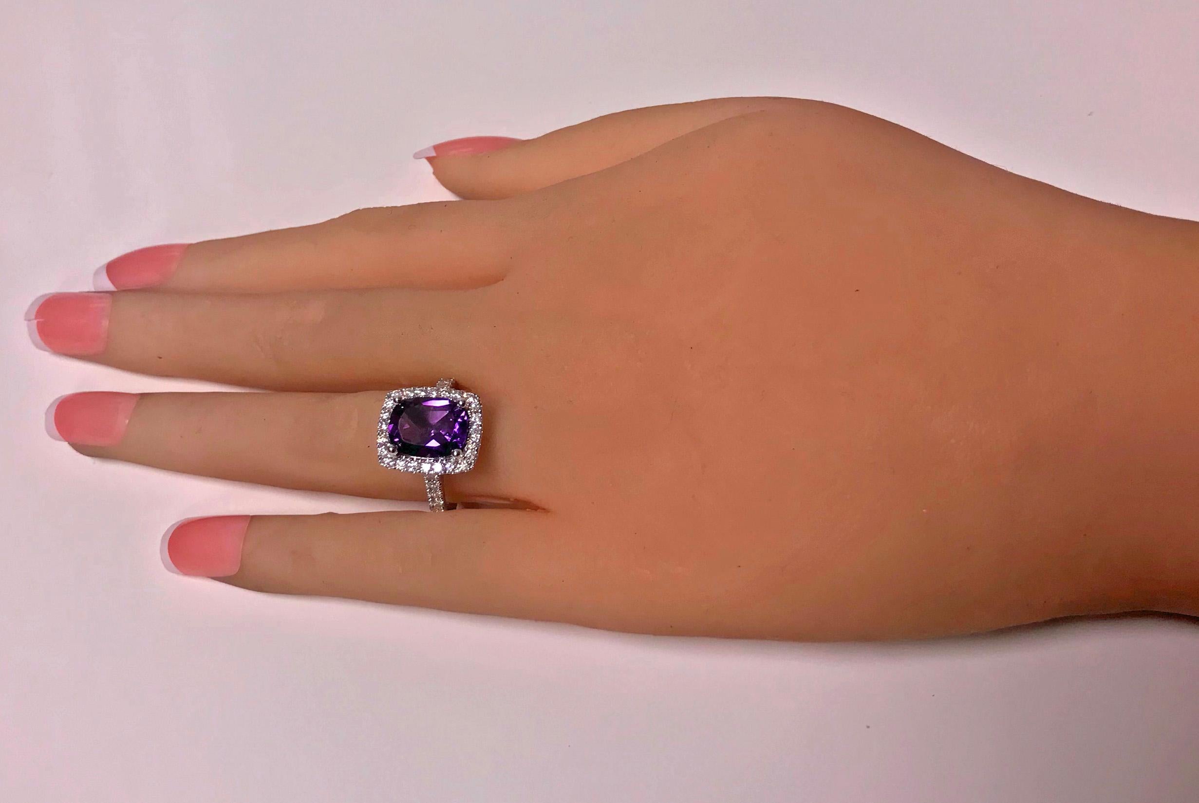 Amethyst and Diamond Ring, 14K white gold. The Ring claw set with a fine medium, moderately strong  purple rectangular cushion cut Amethyst, gauging approximately 10.00 x 8.00 x 5.00 mm, approximately 2.50 cts, the mount and shoulders set with a