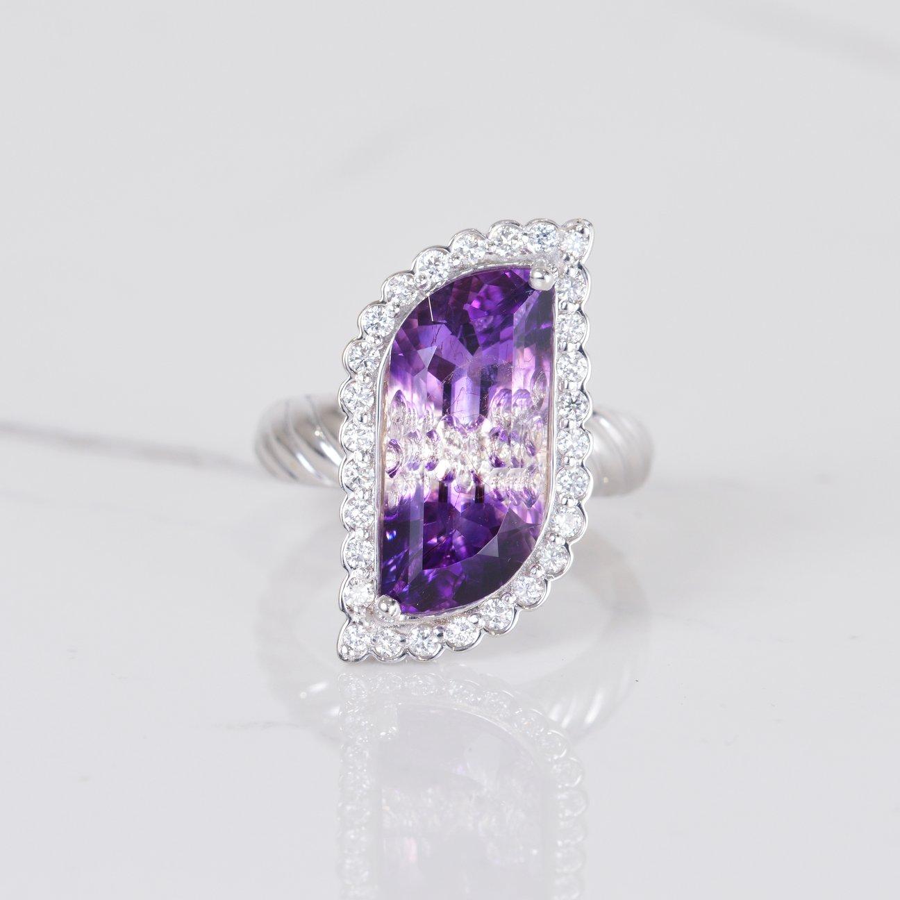This ring is truly magnificent! The center stone is a unique and gorgeous 5.58 carat bi-color amethyst that was cut by an award winning gemstone cutter here in Arizona. Accenting this one of a kind stone is .44 carats of beautiful diamonds. All set