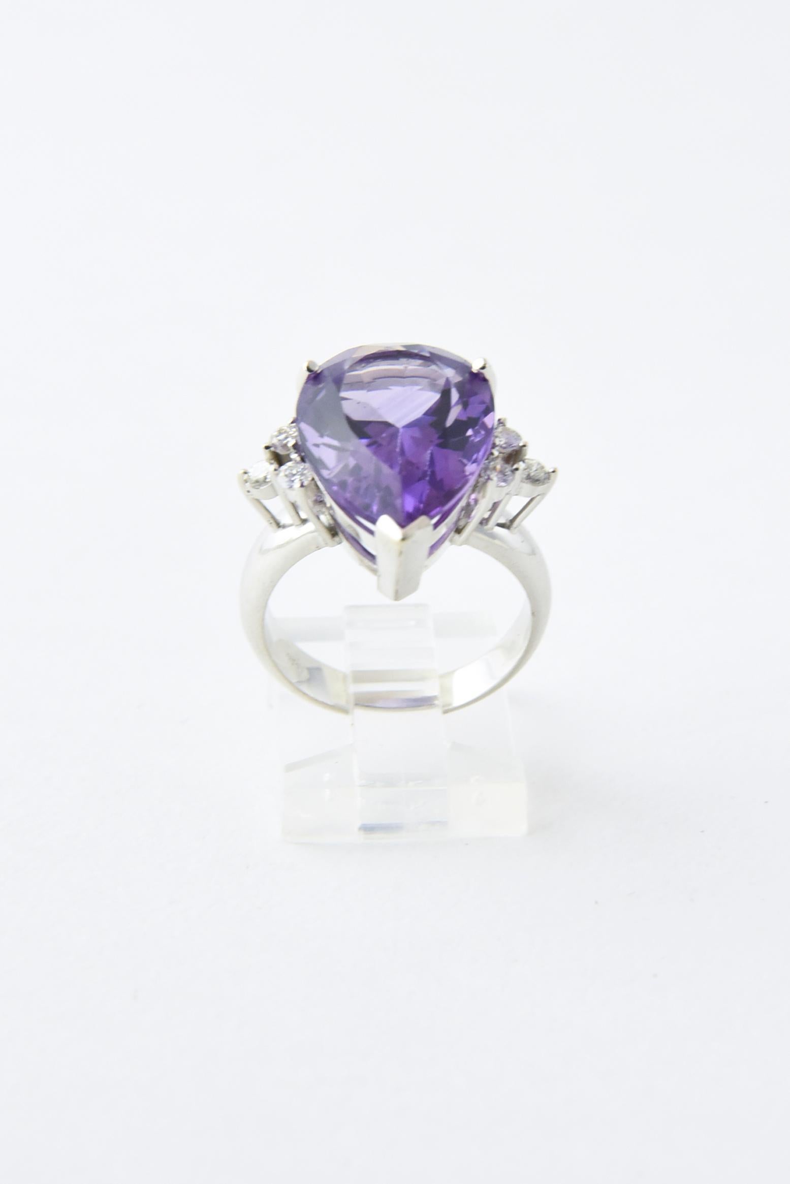 14K white gold ring presenting a faceted pear-shaped amethyst accented with three prong-set diamonds on each side. Amethyst, approximately 9 carats. Diamonds, .05 carats; G-H VS-SI. US size: 6 3/4; can be sized. Light age wear.