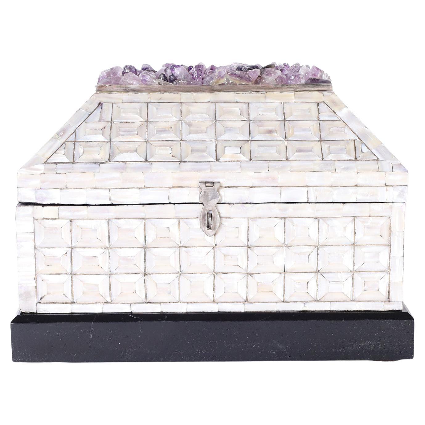 Anglo Indian style hinged box ambitiously covered in a mother of pearl geometric mosaic and featuring a fixed cluster of amethyst stones on top. Stamped 
