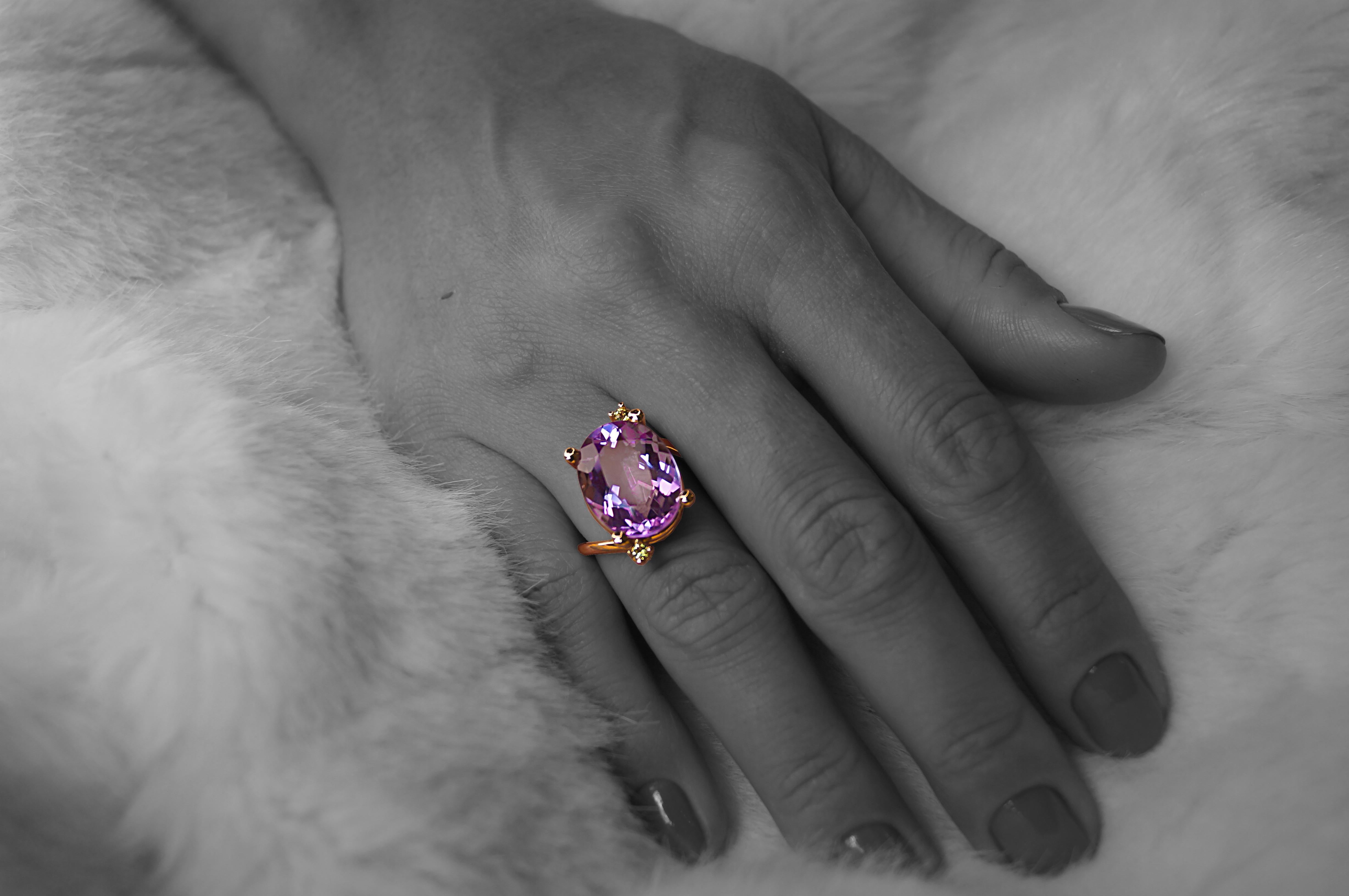 Questo anello, caratterizzato da una splendida ametista ovale con taglio a stella del peso di 10 carati e da due peridoti verdi, è incastonato in oro rosa a 18 carati e disegnato personalmente da Alexander Leyser. Il nome dell'anello è 
