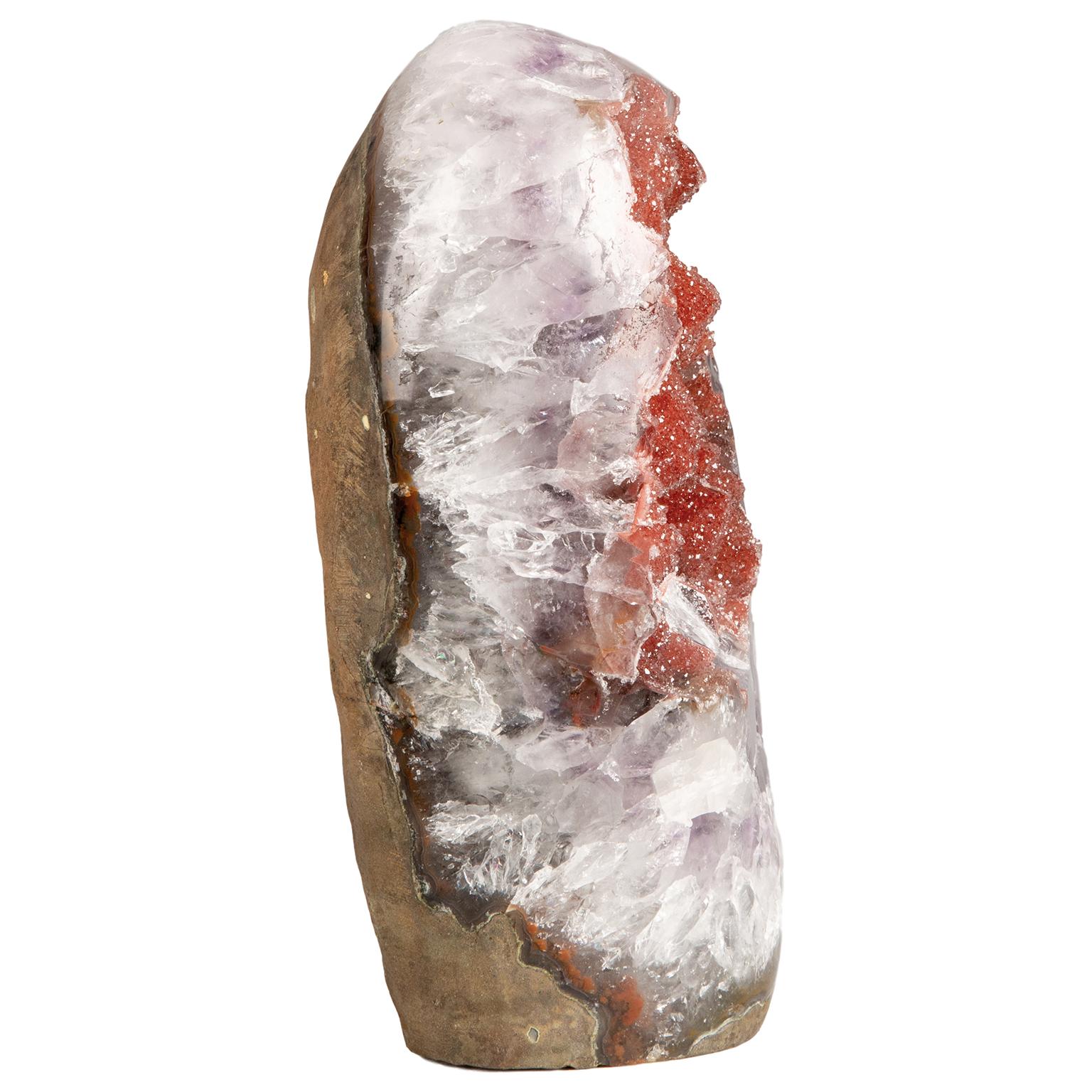 A very unusual and stunning formation with a mix of minerals and beautiful fusion of colors.

This freestanding piece conserves part of the original geode and it is still possible to appreciate the basalt at the back in its rough state. 

The