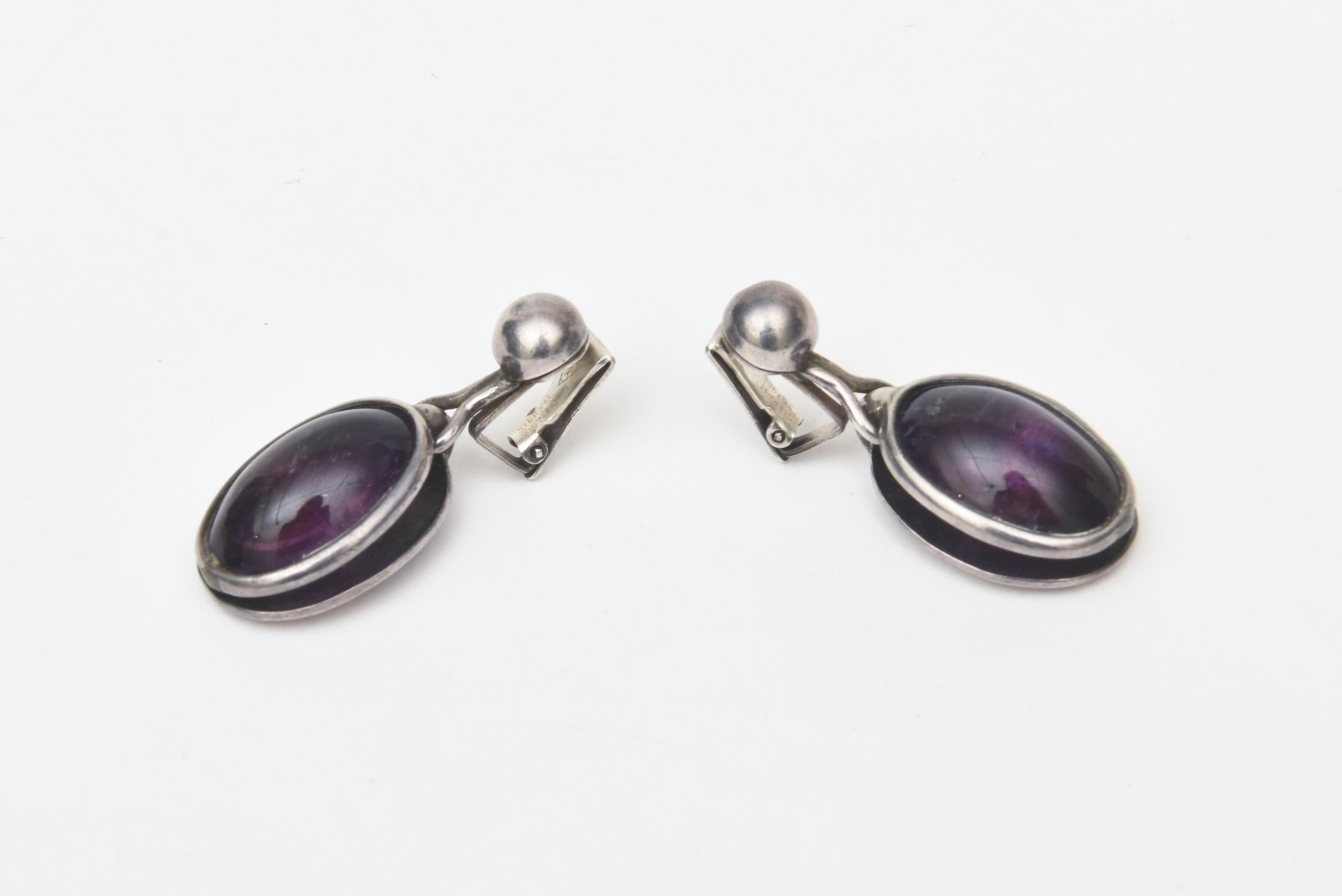 This stunning pair of vintage 1950's clip on drop dangle earrings are amethyst and sterling silver. They are mid century from the time period but remain modern in design and look. Beautifully made. They are marked Sterling Pat. 967965. Amethyst