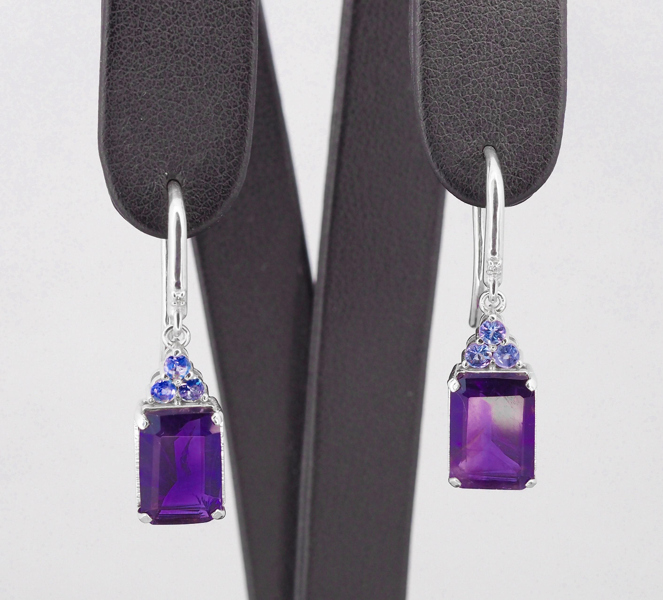 Amethyst and tanzanite in 925 silver earrings.

Metal type: 925 silver
Weight: 5.3 g.
Size 33x8.5 mm.

Set with amethyst, color - violet
Emerald cut, apx 5 ct. in total.
Clarity: Transparent with inclusions

Surrounding stones:
tanzanites 6 pieces -
