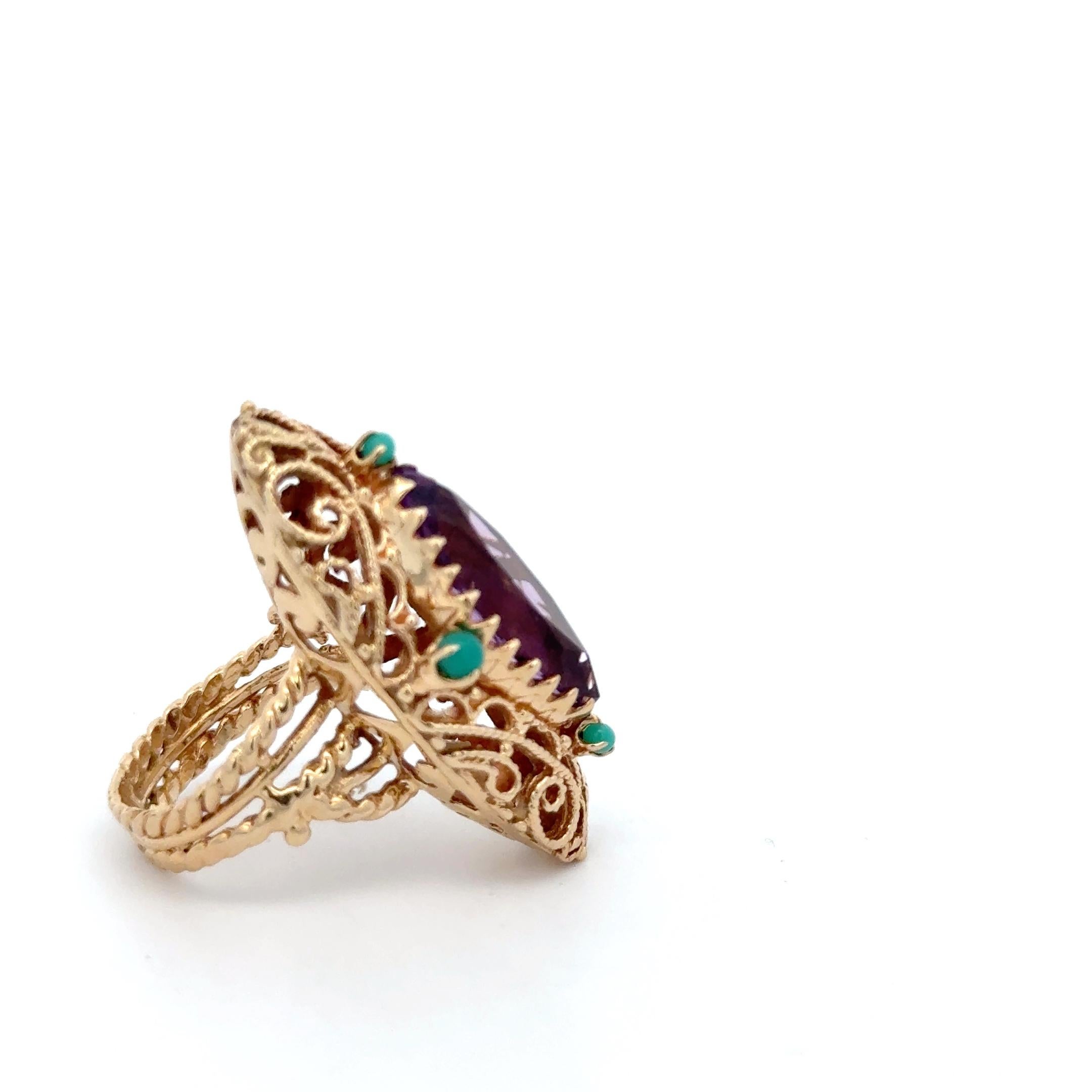 Bague en or jaune 14K avec améthyste et turquoise. La bague est ornée d'une améthyste taillée en marquise et rehaussée de turquoise. La bague mesure environ 1,5
