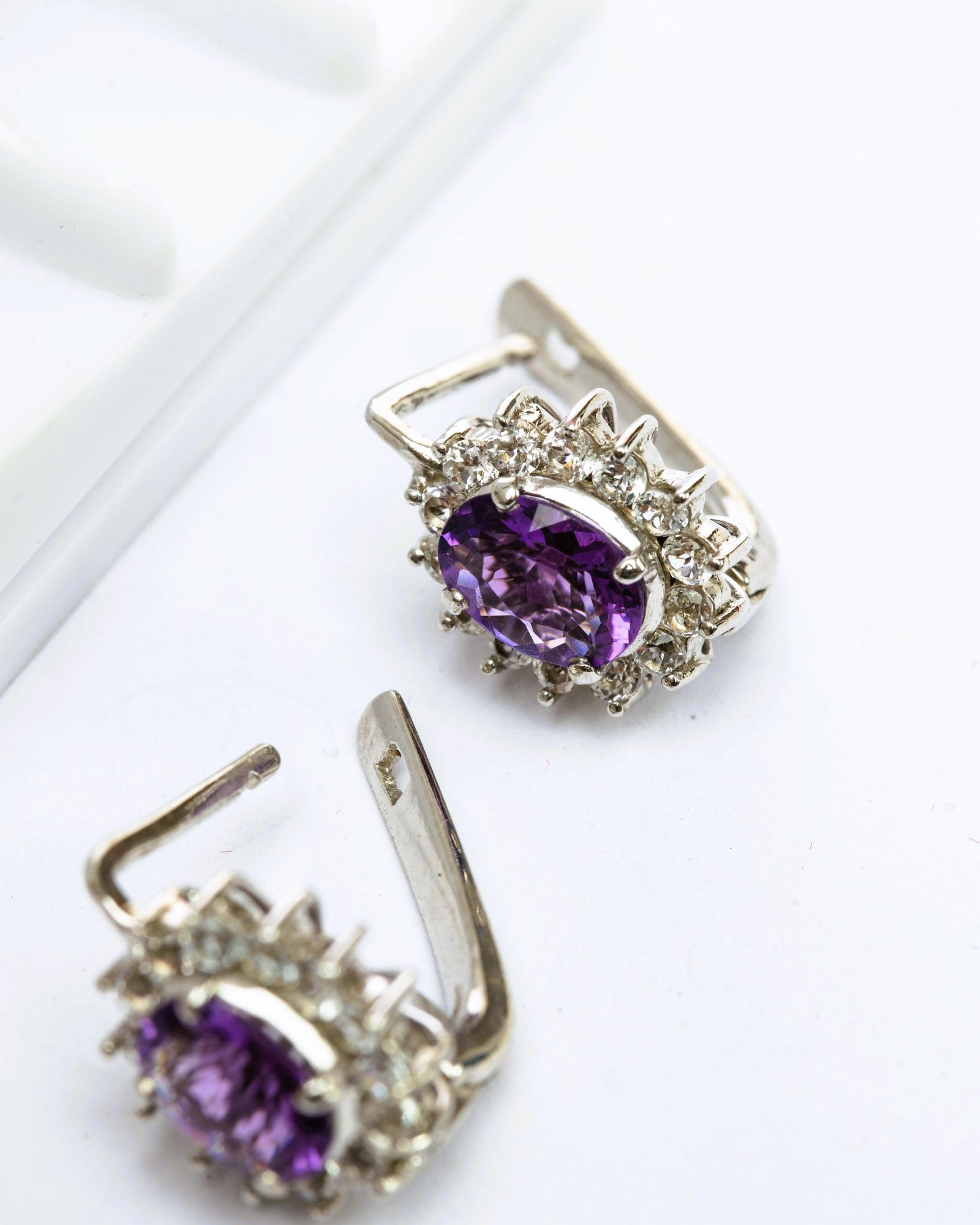 An exquisite 2.5ct Oval Amethyst and Zircon  Plug Earring, a masterpiece that infuses elegance into your every moment.
At the heart of this earring lies a captivating 7.2x6.8mm oval Amethyst gemstone. Known for its enchanting purple hue, the