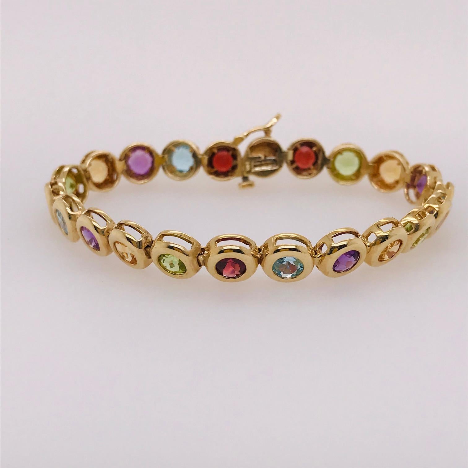 This fun, retro, one of a kind bracelet is so adorable! With genuine gemstones going around the bracelet set in a retro bezel design. The bracelet is 14k yellow gold and 7 inches long. The alternation gemstones are genuine Amethyst, aquamarine,