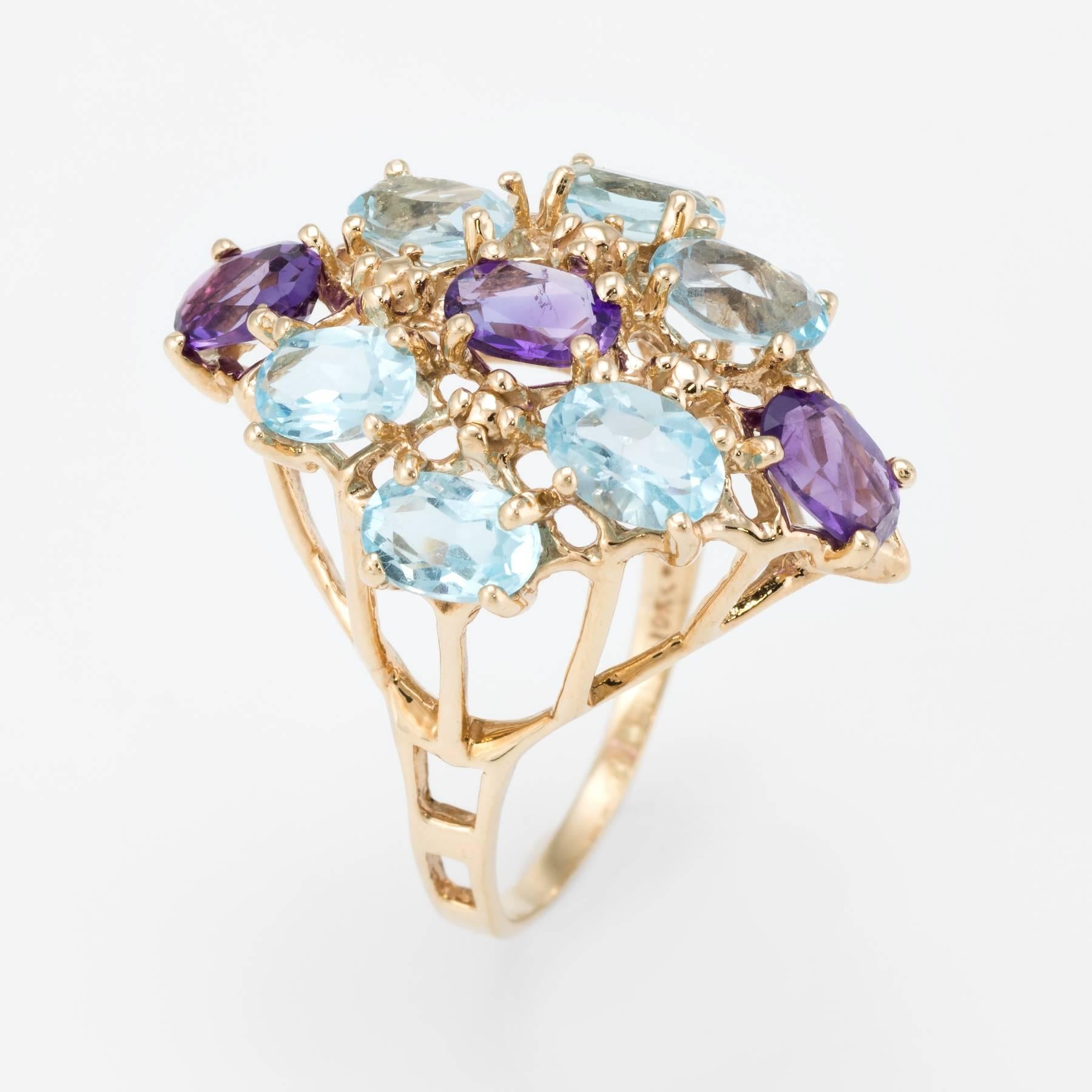 Elegant estate cocktail ring, crafted in 10 karat yellow gold. 

Faceted oval cut amethyst and blue topaz each measure 6mm x 4mm. The amethyst totals an estimated 1.15 carats and the blue topaz totals an estimated 3 carats. The stones are in