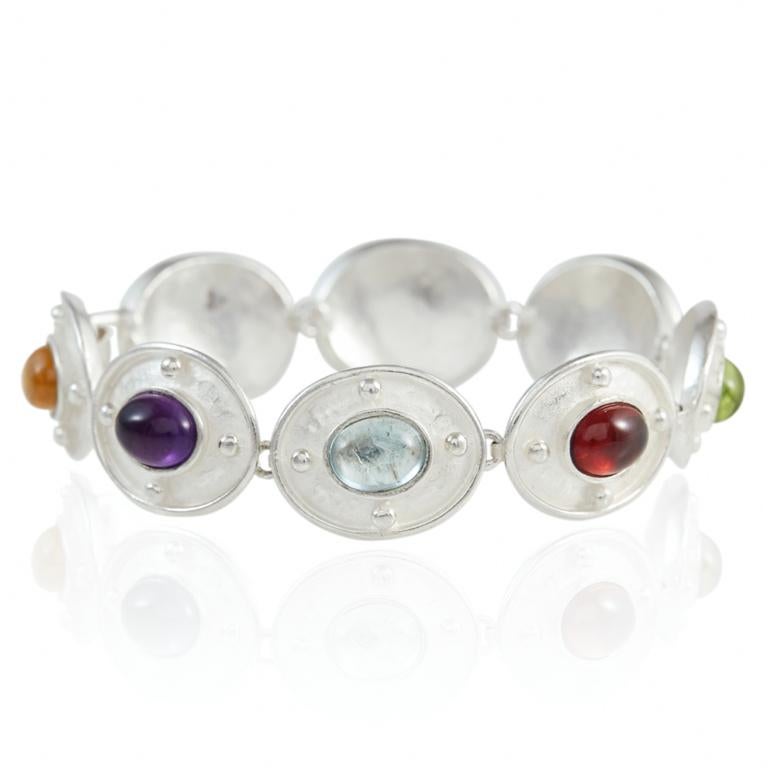Colourful bracelet, set in sterling silver with a selection of different cabochon stones of amethyst, blue topaz , garnet, peridot, iolite and carnelian. Please note this item is made to order and a similar but not identical piece can be made. Allow