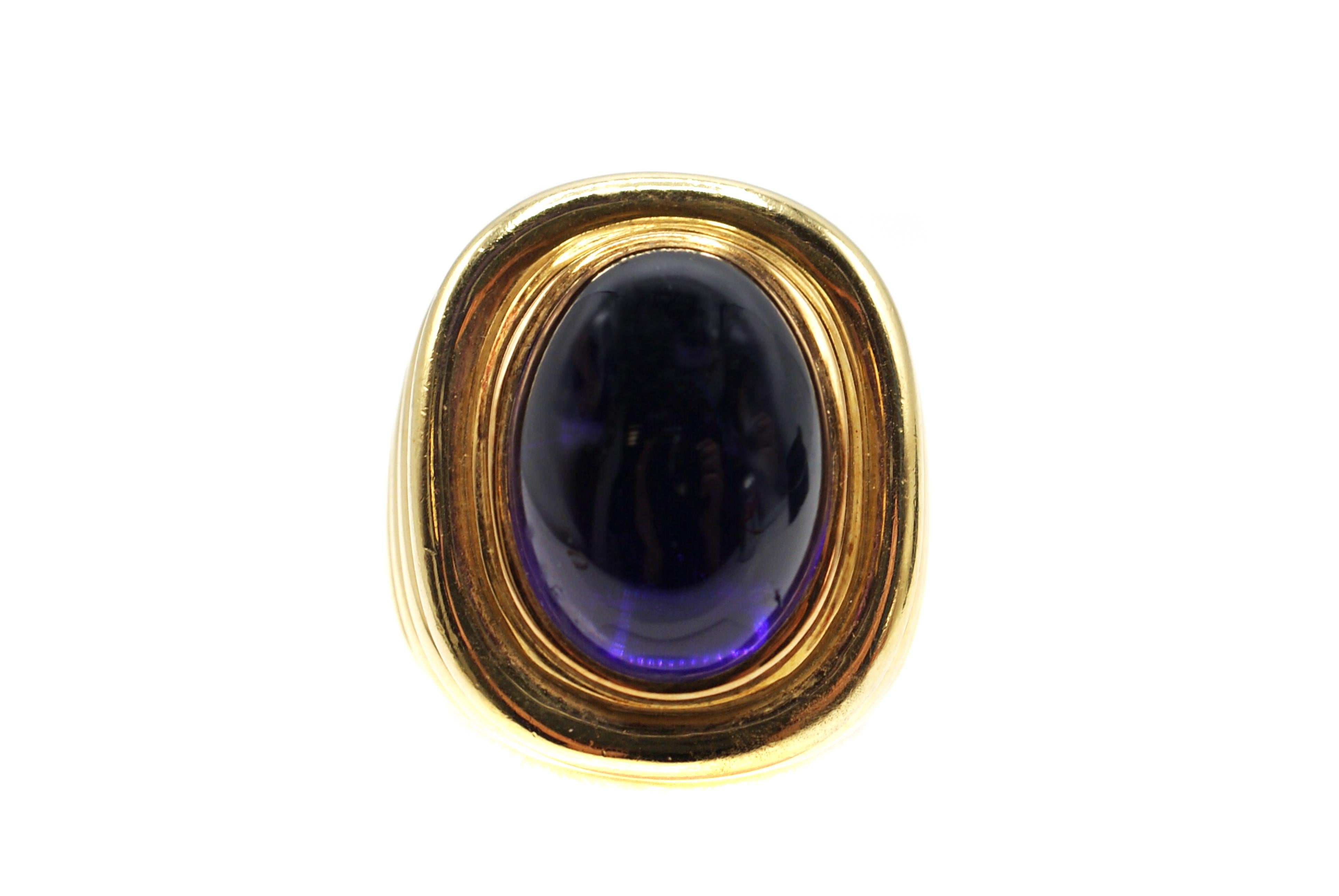 This chic and stylish ring, wonderfully handcrafted in 18 karat yellow gold features an Amethyst cabochon measured to weigh approximately 9 carats. The oval cabochon has an amazing rich deep purple and well saturated color usually found in amethyst