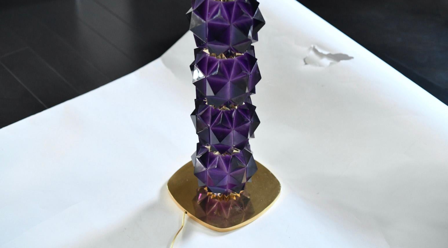 Pair of finely  carved multifaceted  amethyst lamps with polished brass decoration. Created by Phoenix Gallery.
Measures: To the top of rock crystal: 16.5
