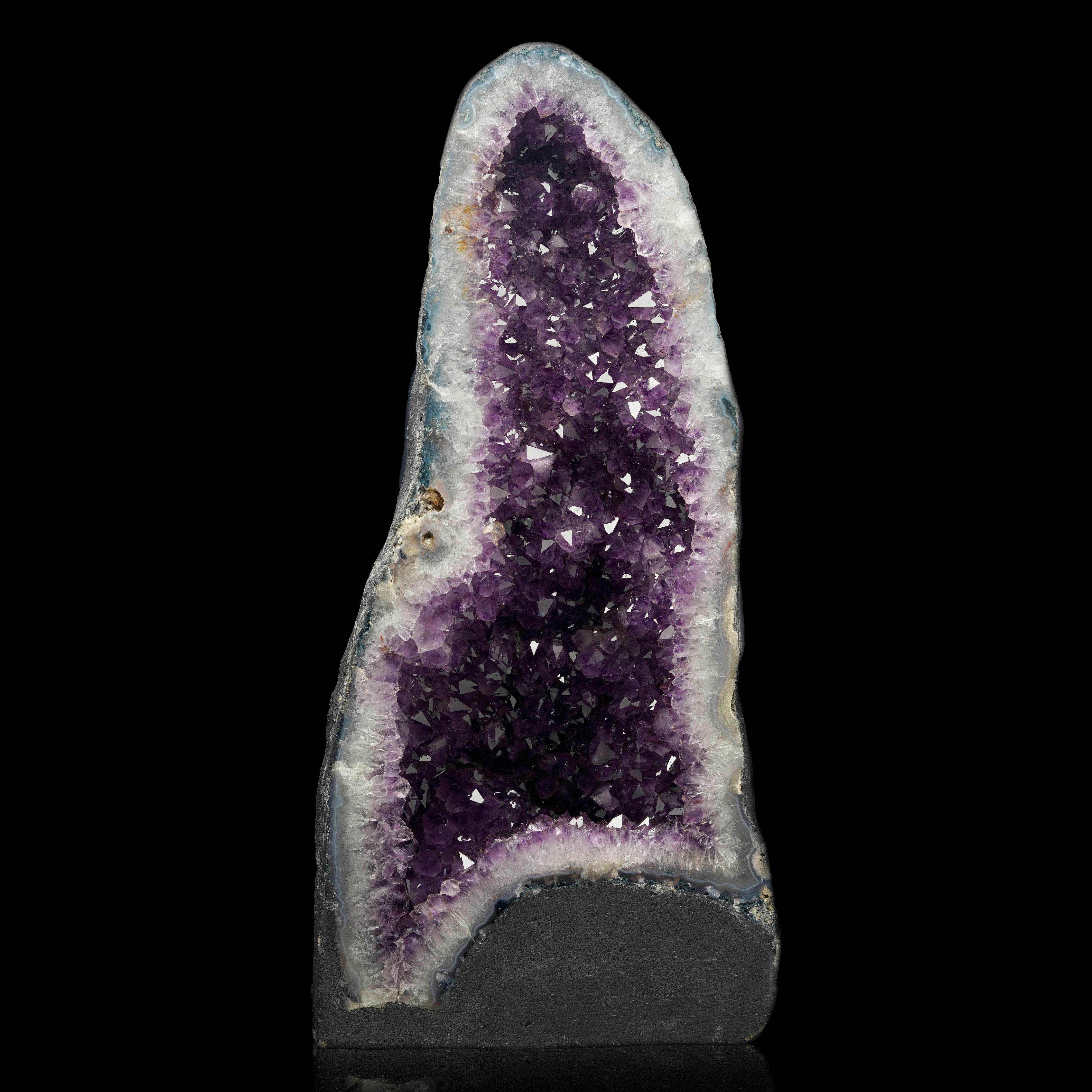 Questa grandiosa cattedrale di ametista proveniente dal Brasile è un magnifico esempio di arte naturale, che si erge con le sue ricche formazioni di cristallo viola. Le sue dimensioni impressionanti e il suo splendore lo rendono un pezzo forte