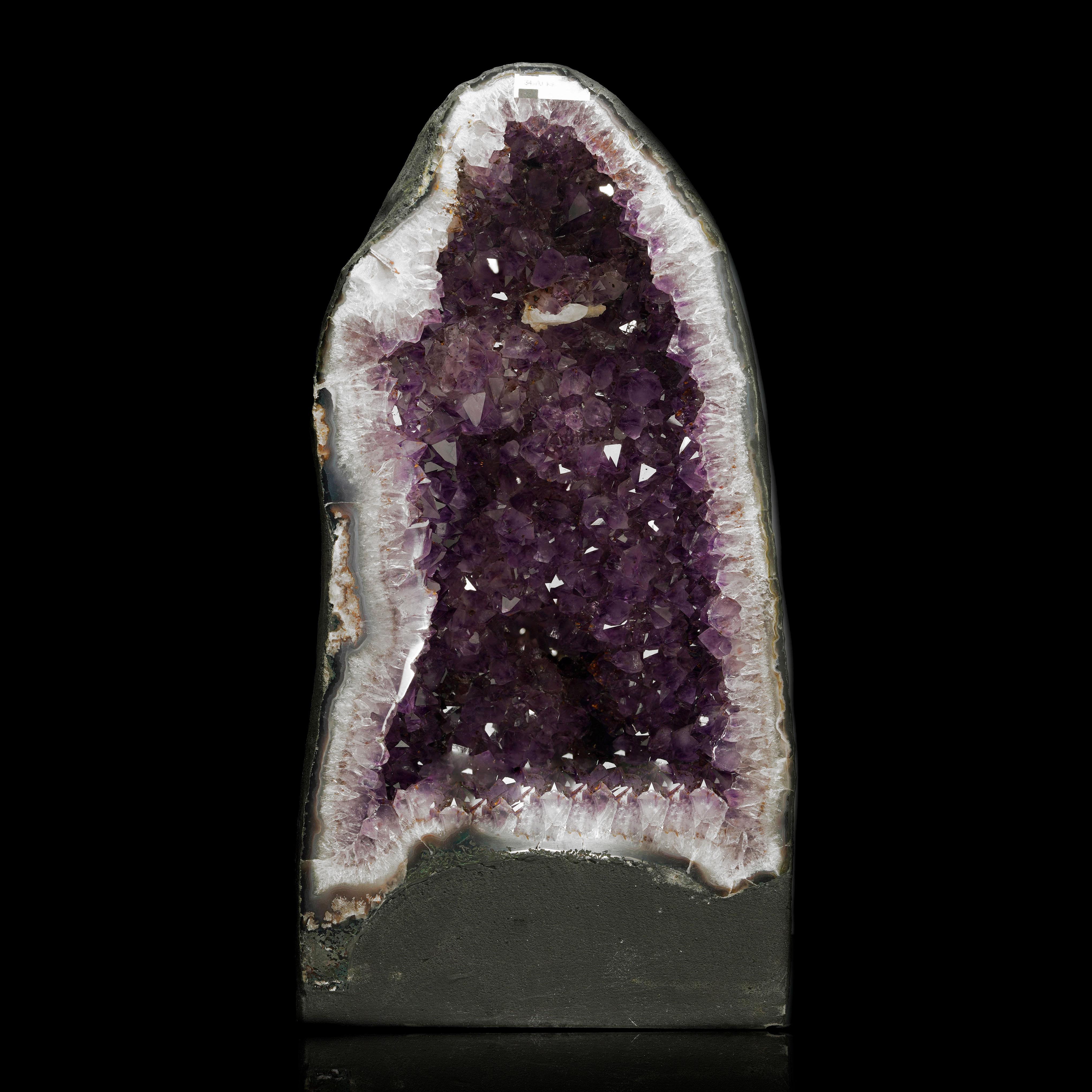 Questa straordinaria cattedrale di ametista proveniente dal Brasile si erge alta, mostrando le sue formazioni di cristallo viola intenso con una chiarezza e una brillantezza notevoli. Le sue grandi dimensioni e la sua intricata struttura cristallina