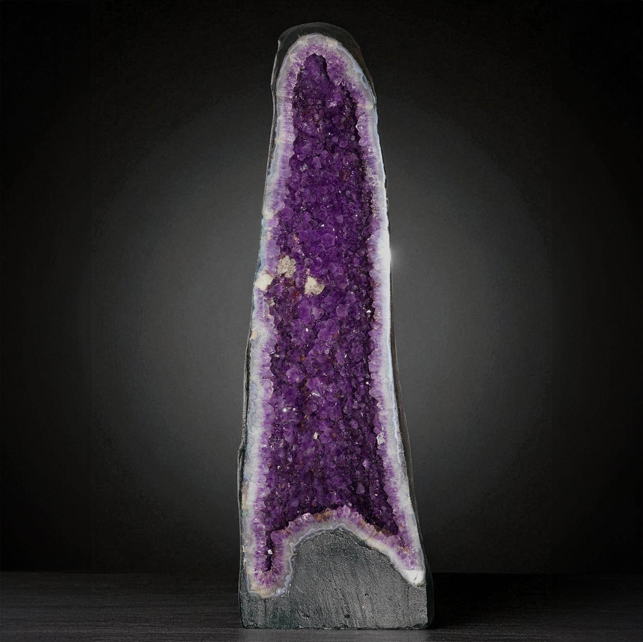Diese auffällige Amethyst-Kathedrale zieht mit ihrer hohen, skulpturalen Präsenz und ihrer lebhaften, natürlichen Farbe die Aufmerksamkeit auf sich. In seinem gewölbten Inneren schimmern zahllose violette Kristalle mit Tiefe und Brillanz, während