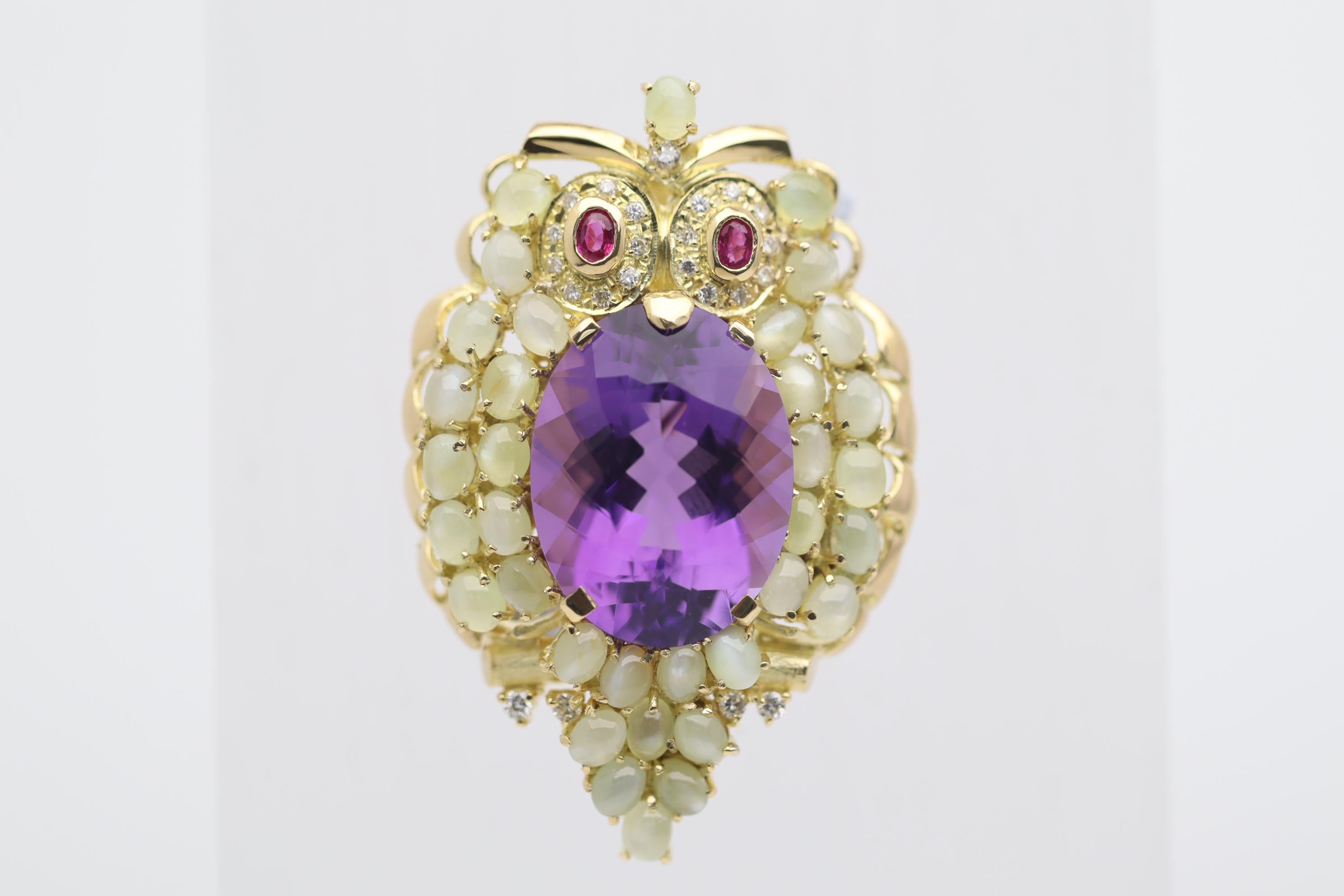 A fine and stylish owl brooch featuring fine and precious gemstones! The center of the own is a 19.30 carat amethyst with a bright rich and clean purple color. Its feathers are multiple cats eye chrysoberyl weighing a total of 11.97 carats. Two