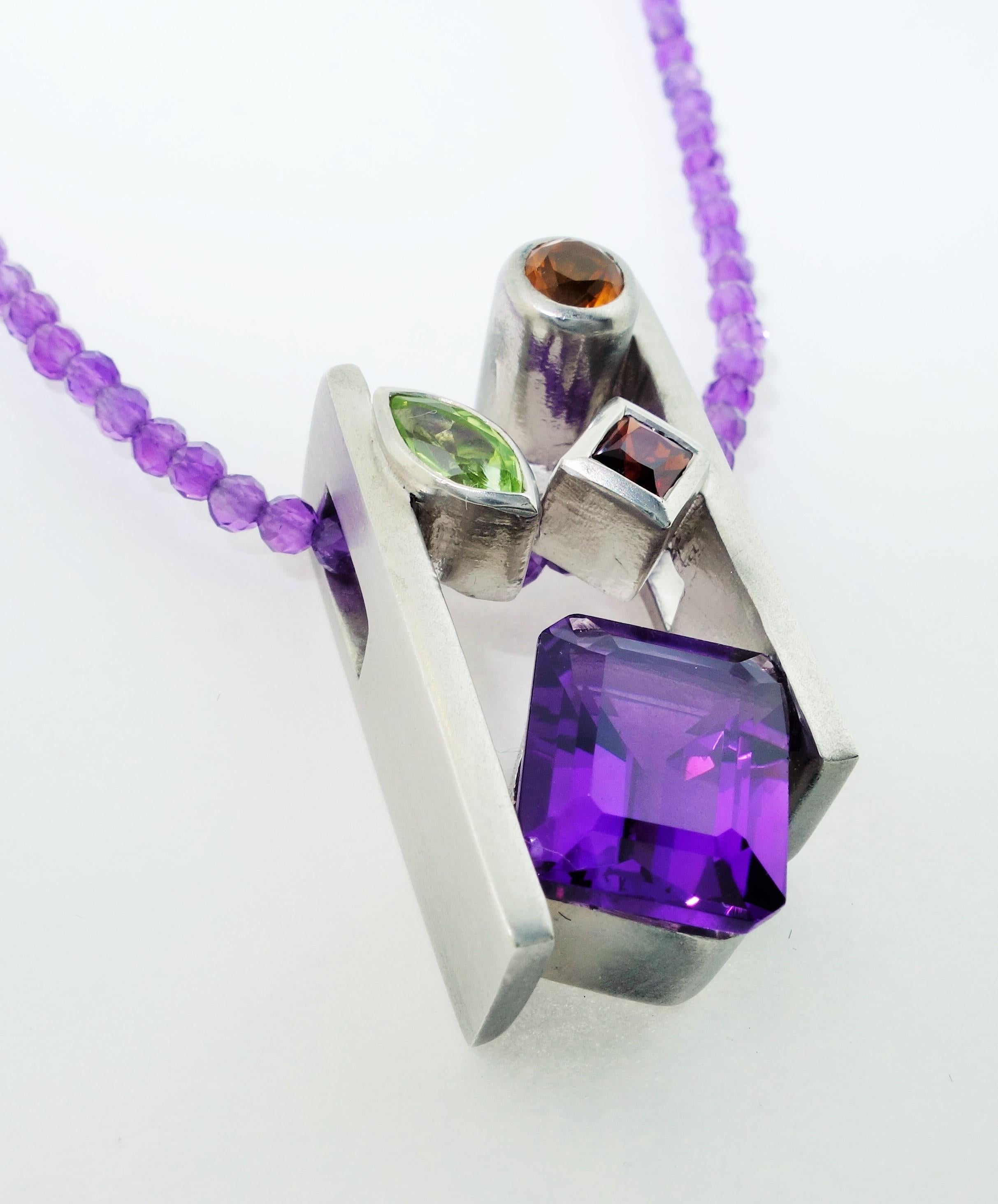 Beautiful and Finely detailed Amethyst, Citrine, Peridot and Garnet Pendant Hand set in Sterling Silver and suspended from a multi colored Amethyst Necklace; approx. total weight of Gemstones: 4.73 Carat. The pendant is Hand crafted in Rhodium