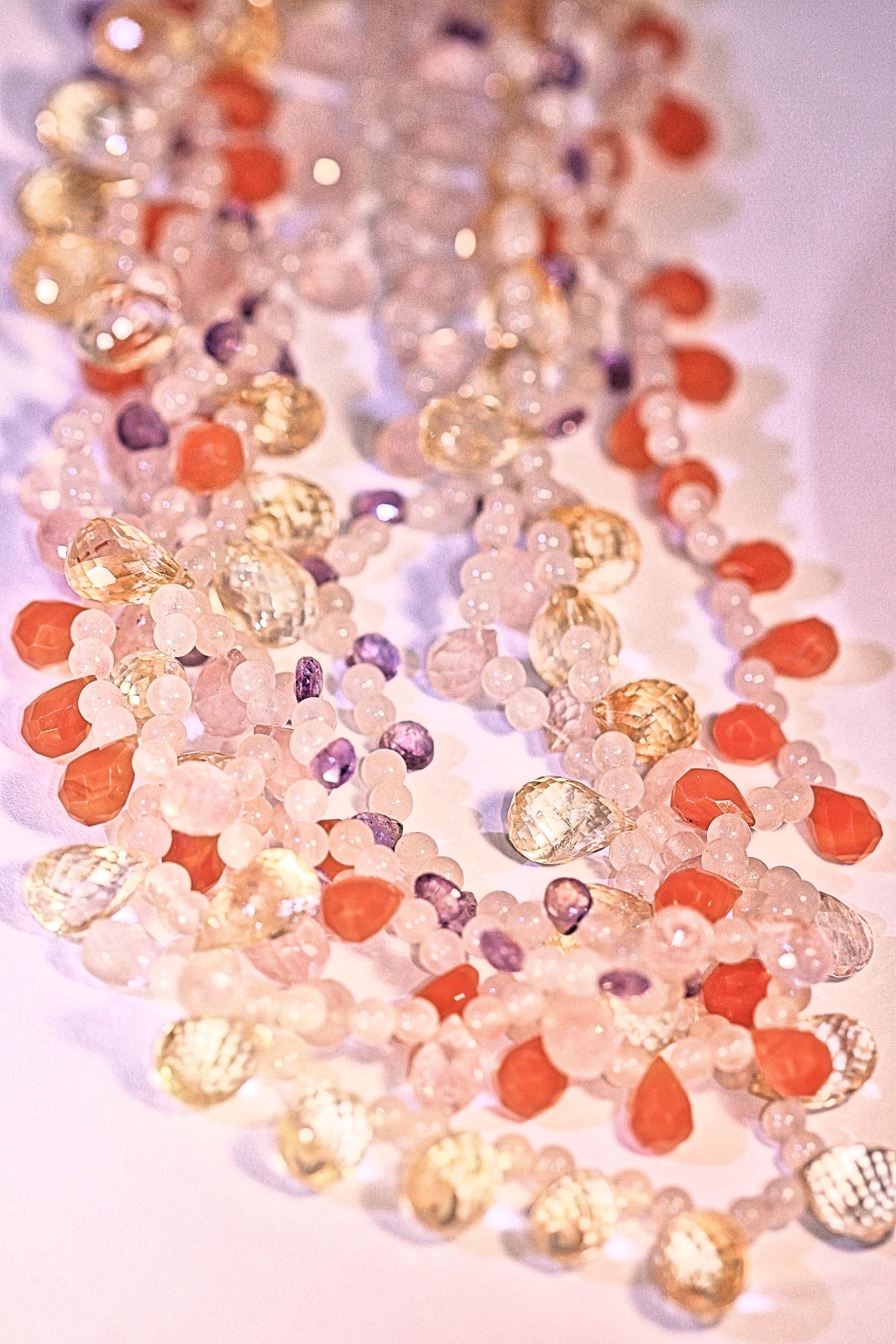 A charming multi-strand necklace with amethyst, citrine, rose quartz and carnelian semi-precious
stones.  The semi-precious stones are faceted teardrop and round shaped stones.  The clasp is 
18 karat yellow gold and the necklace is 18 inches long.