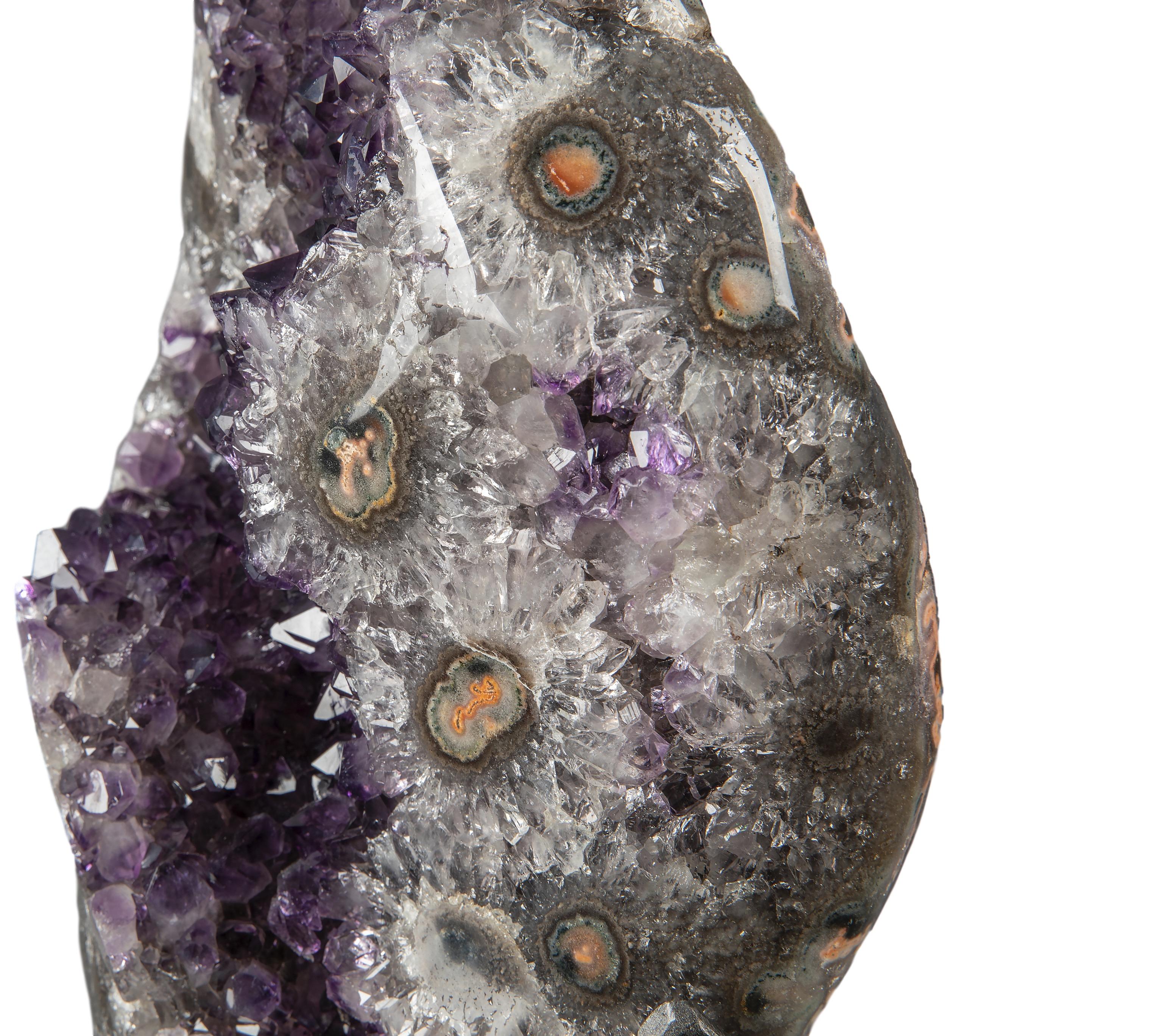Minerals fuse together in this uniquely beautiful piece, presenting the viewer with deep purple amethyst and a mix of white quartz, green celadonite, grey, brown and some artful inflections of pink and orange agate.  Rare in the unique spectrum of