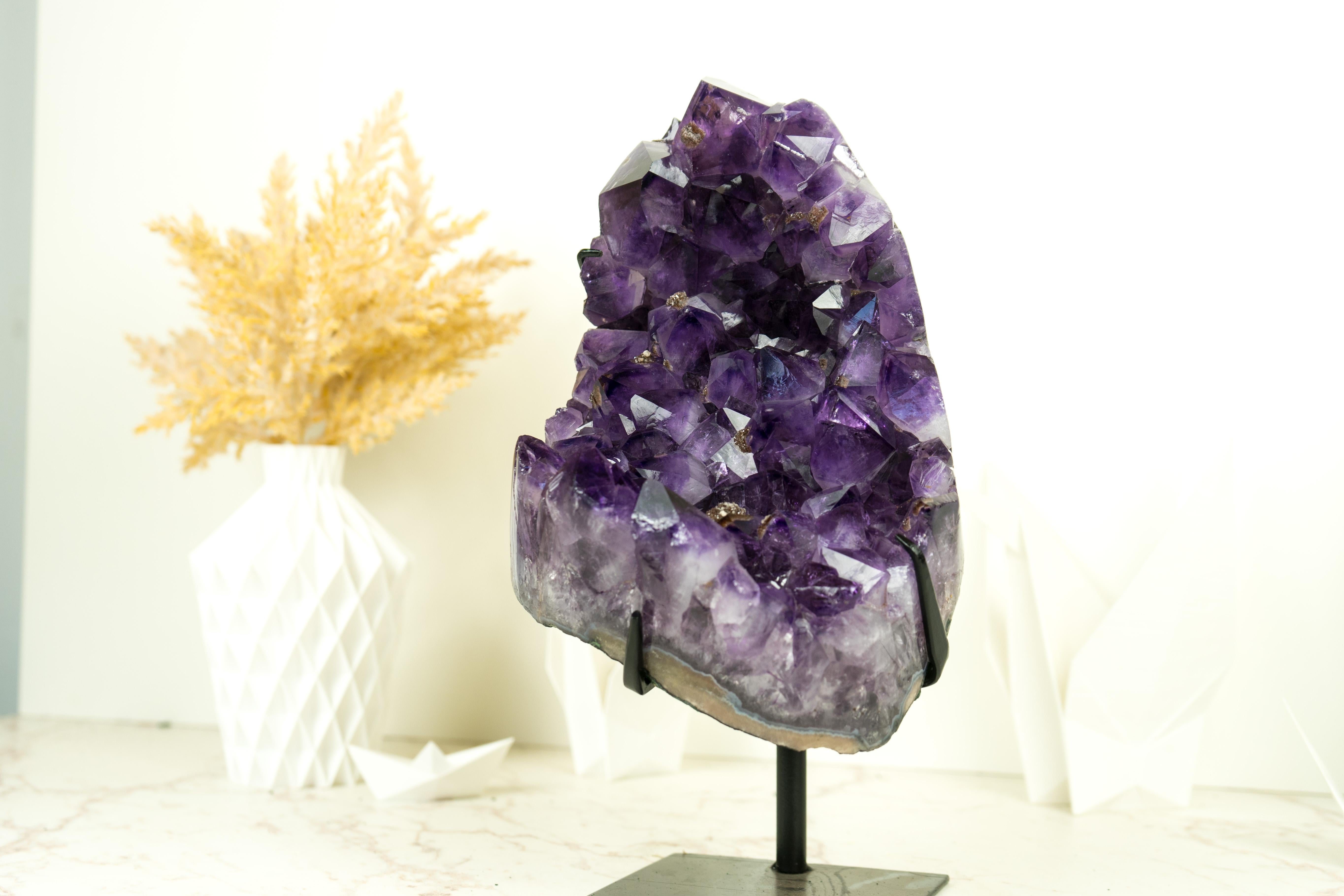 With an intense shade of purple, as if violet meets black, on large Amethyst points, this cluster showcases the best quality an Amethyst can have. Set on a made-to-order stand, this specimen will be the centerpiece of your decor or