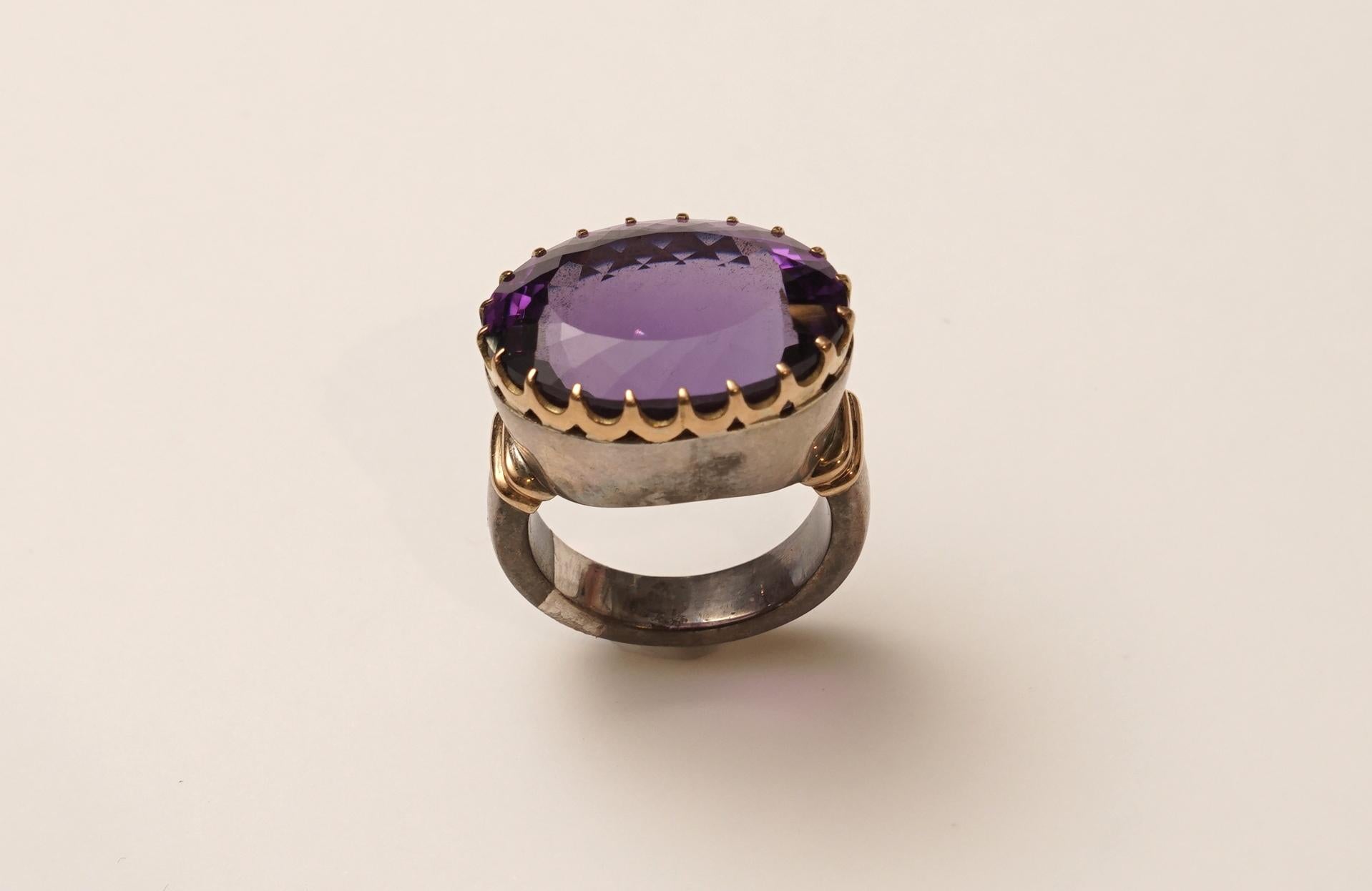 A large, faceted and bezel-set natural amethyst set in a combination of 18K gold and sterling silver.  This is not a plated gold over sterling, just a combination of the two metals. Excellent quality amethyst and a magnificent size.
