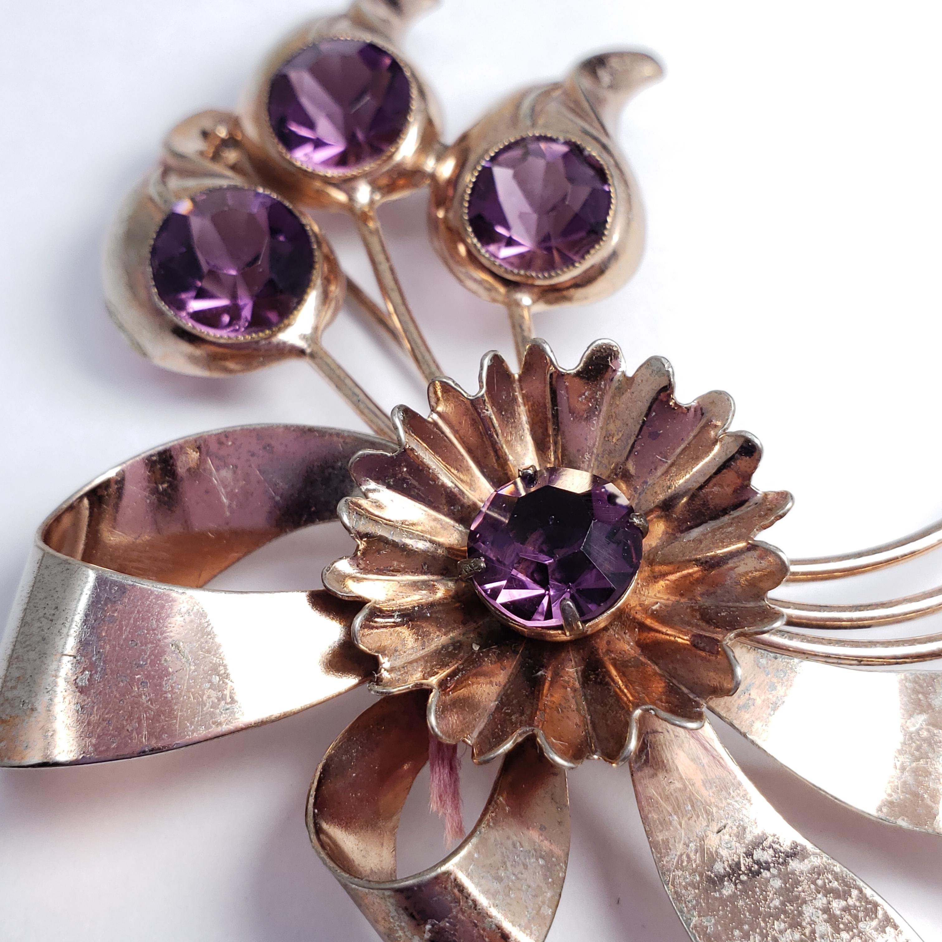 An elegant floral pin brooch! Features an assortment of flowers with amethyst crystal centers. Sterling silver.

Hallmarks: Sterling