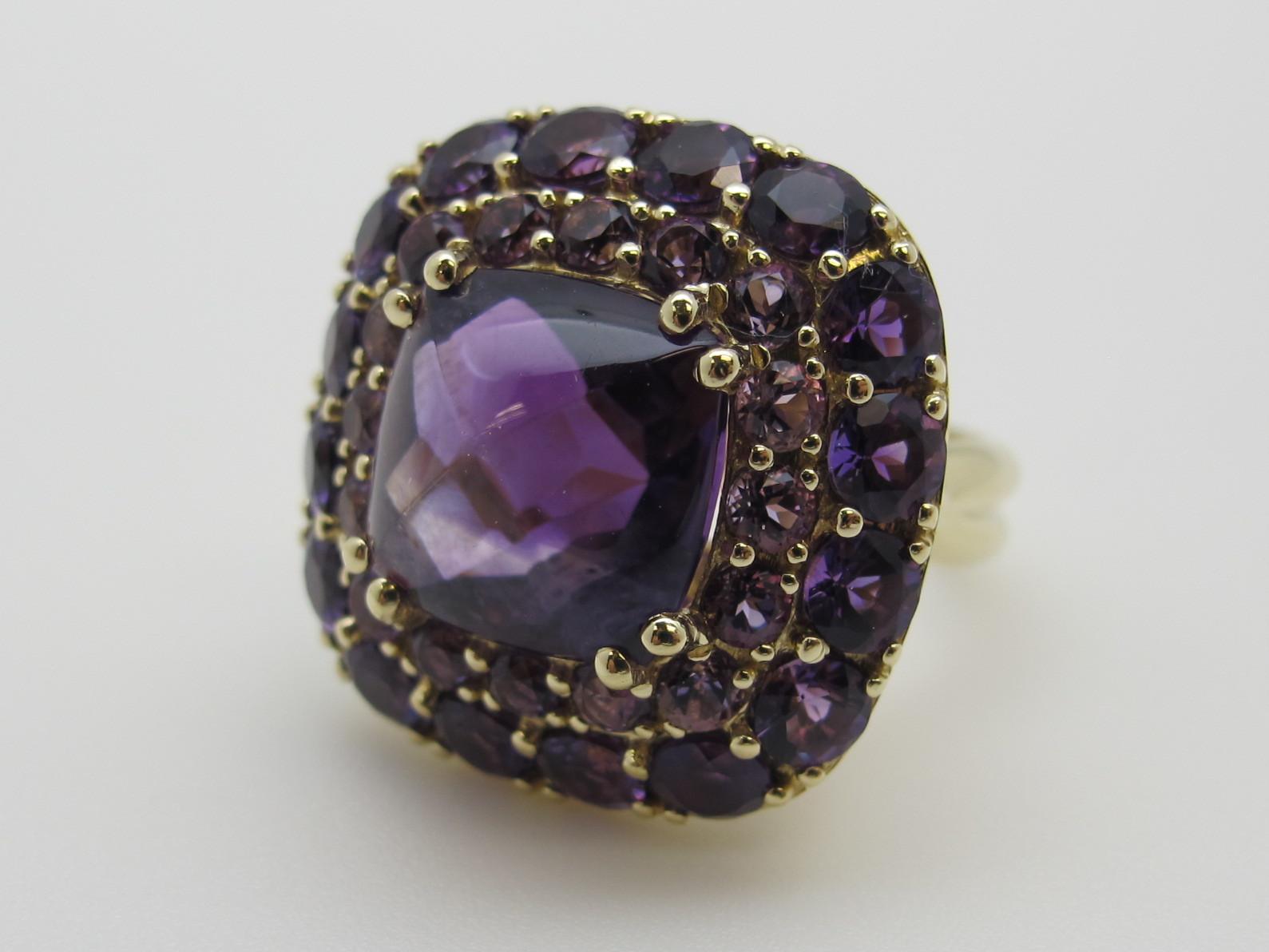 This tone-on-tone amethyst  cocktail ring features amethysts in 3 flavors! The center stone is a cushion cut cabochon (11.5x11.6x9.4mm /8.60carats).  Seventeen round, facetted,  light purple amethysts (2.7mm /1.49 carats total weight) and 17 round