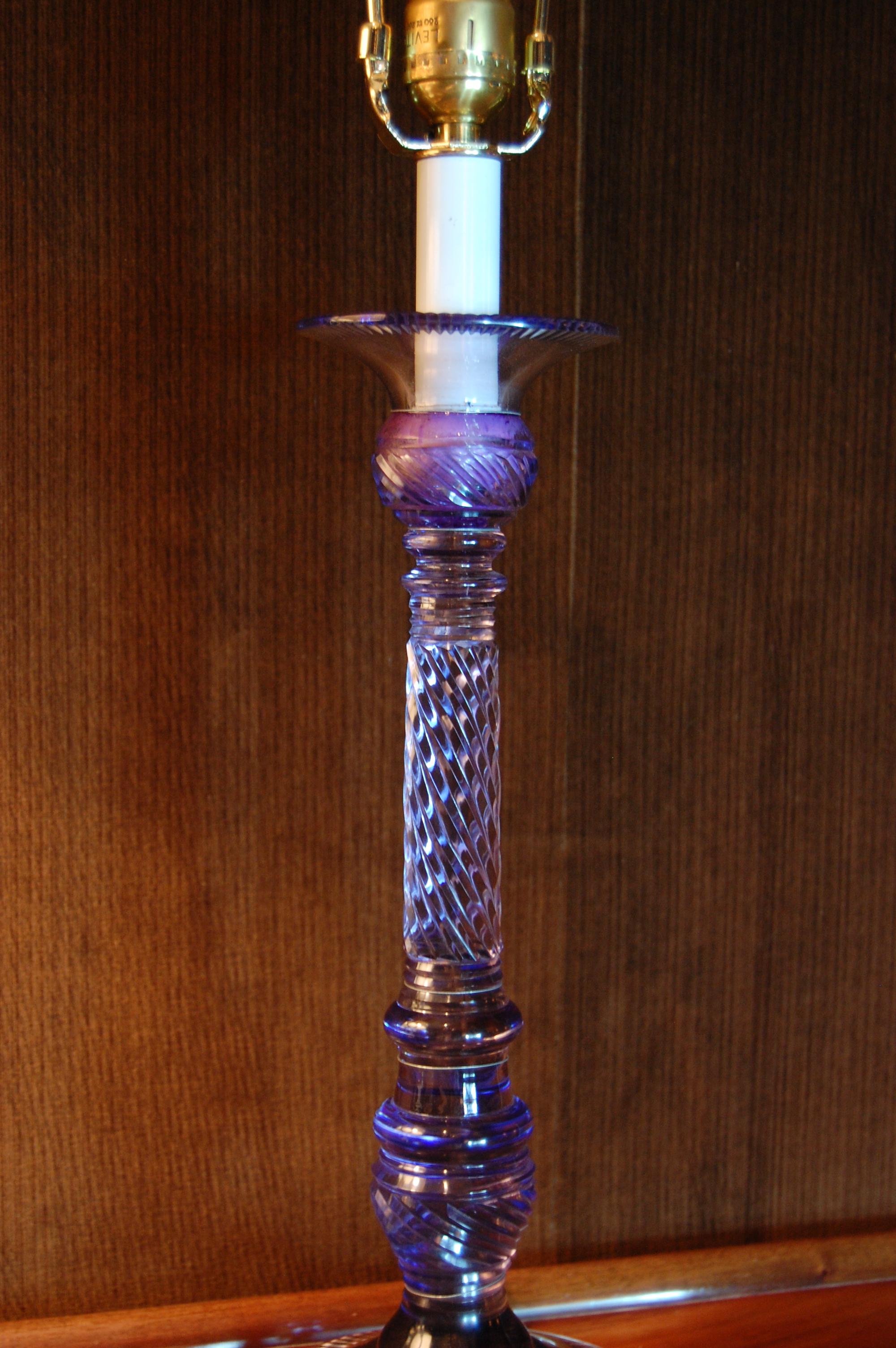 Cut-glass candlestick wired as a lamp with the wiring run on the exterior. The glass has not been drilled either top or bottom. Excellent condition. It measures 14 1/2 inches to the lip of the glass.